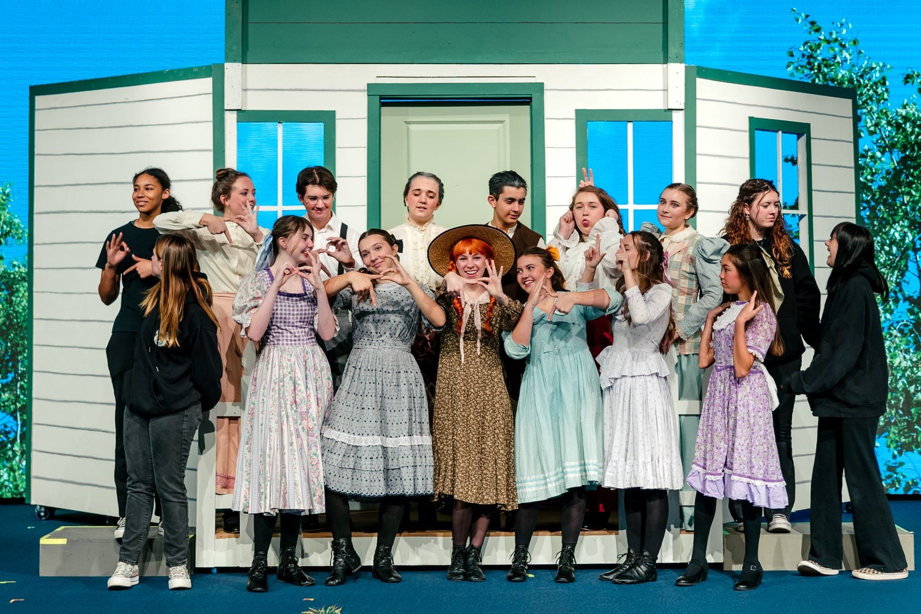 Christian Unified Schools cast poses together in front of the house set