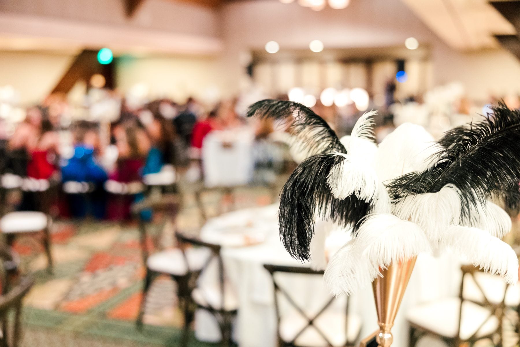 Ostrich feather centerpiece decorates banquet table at Catamaran Resort event