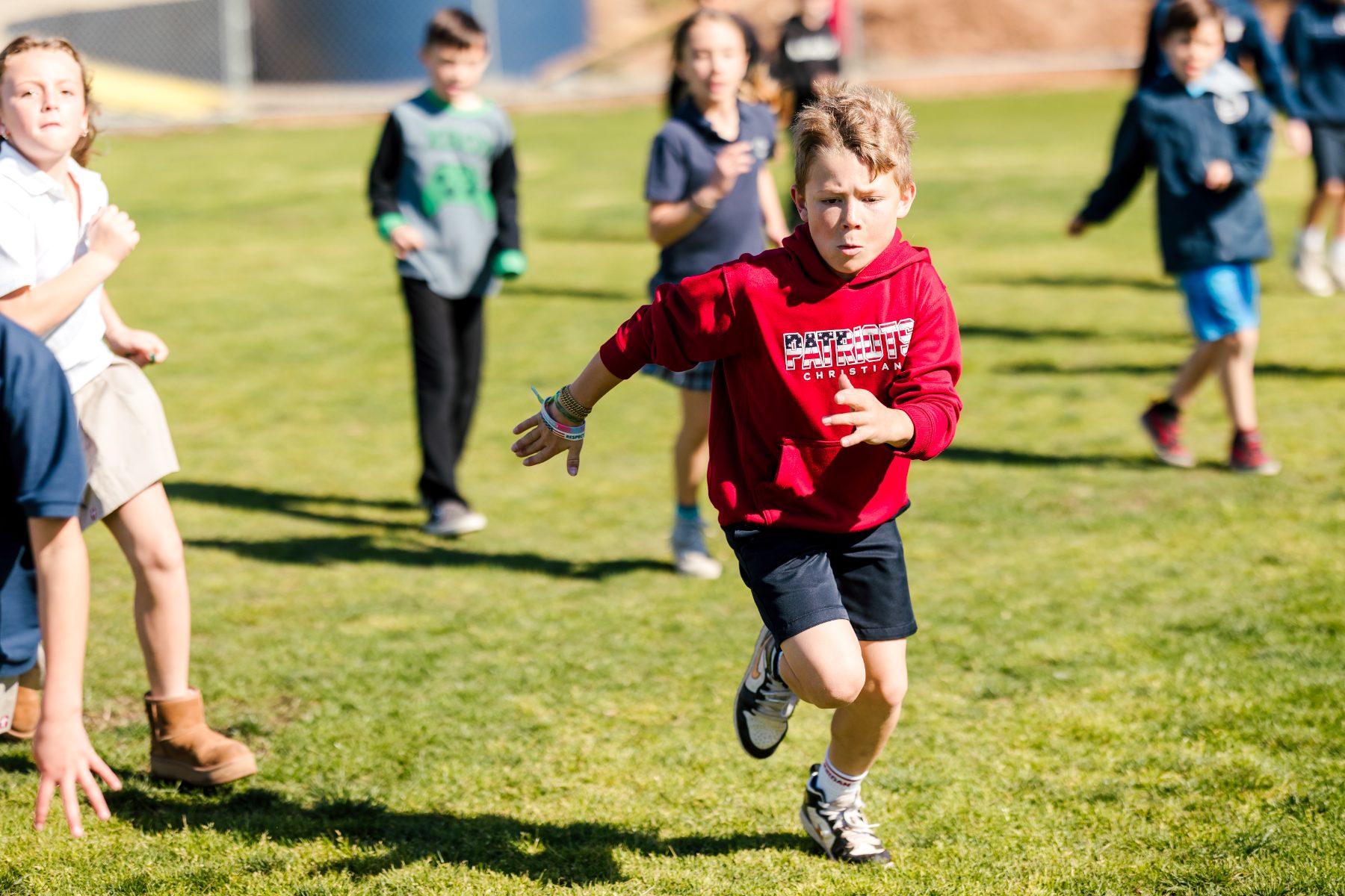 A student sprints across the field during PE at Christian Elementary School