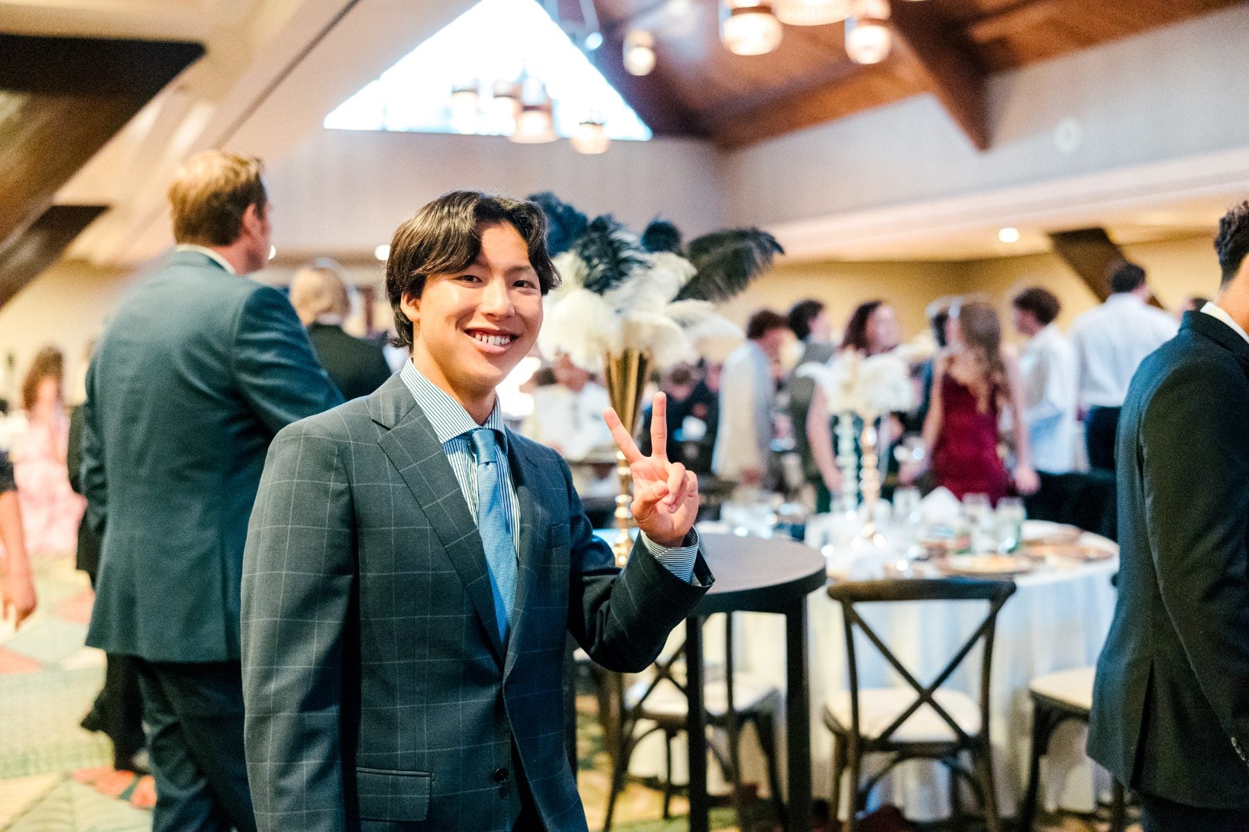 A Christian High School Patriots student smiles with peace sign at banquet