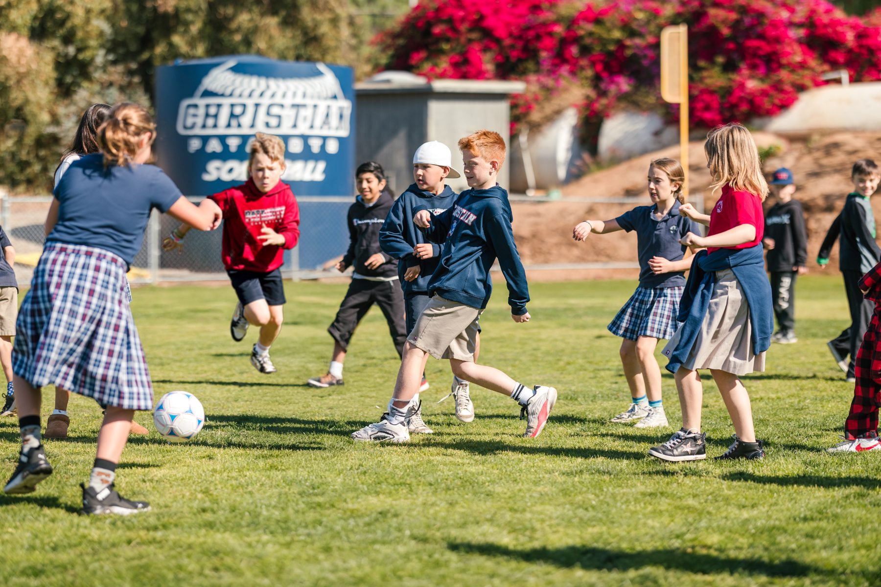 Students chase a soccer ball during recess on the elementary field