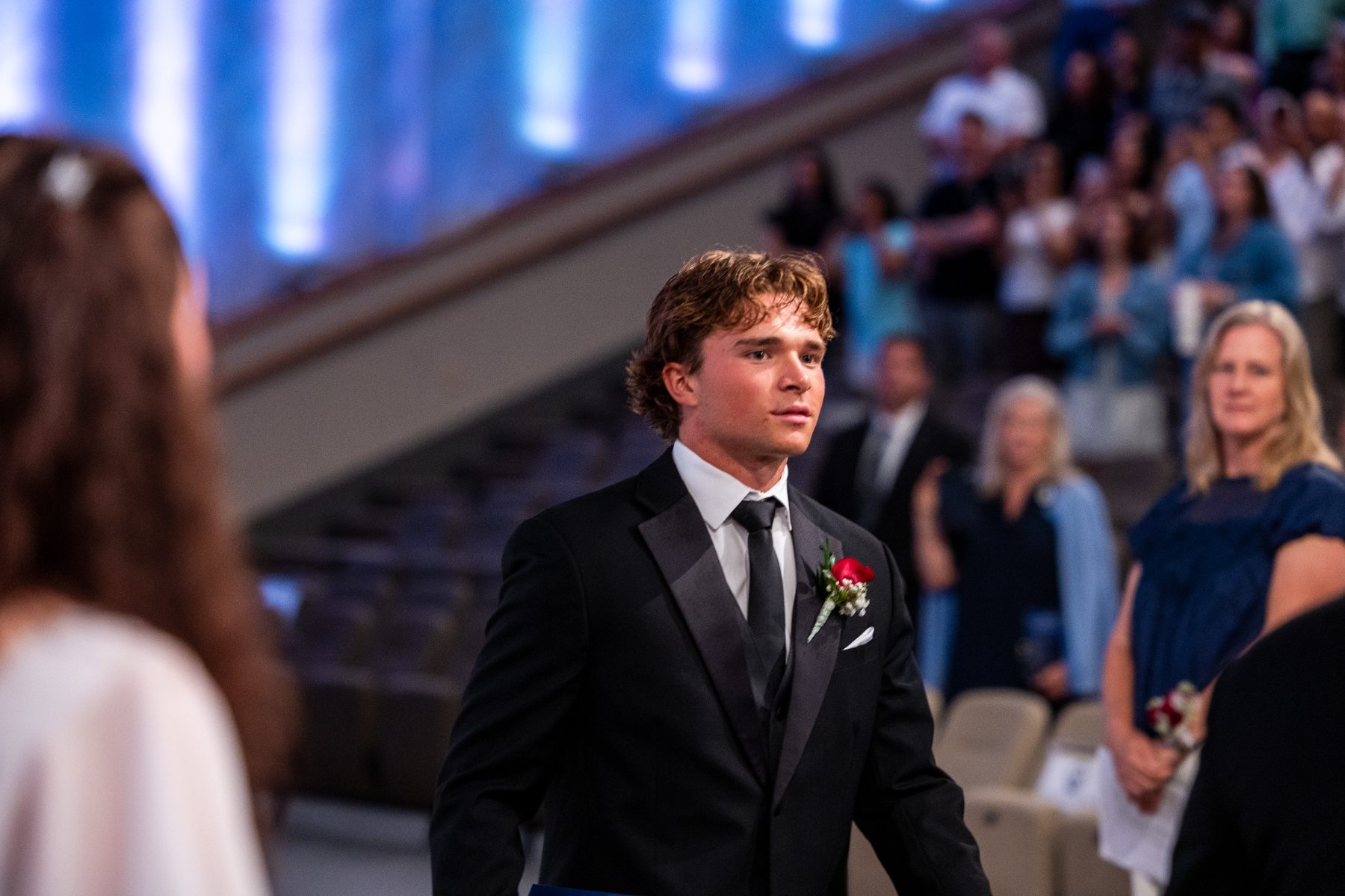 A Christian High School Patriots graduate walks down the aisle in a tuxedo