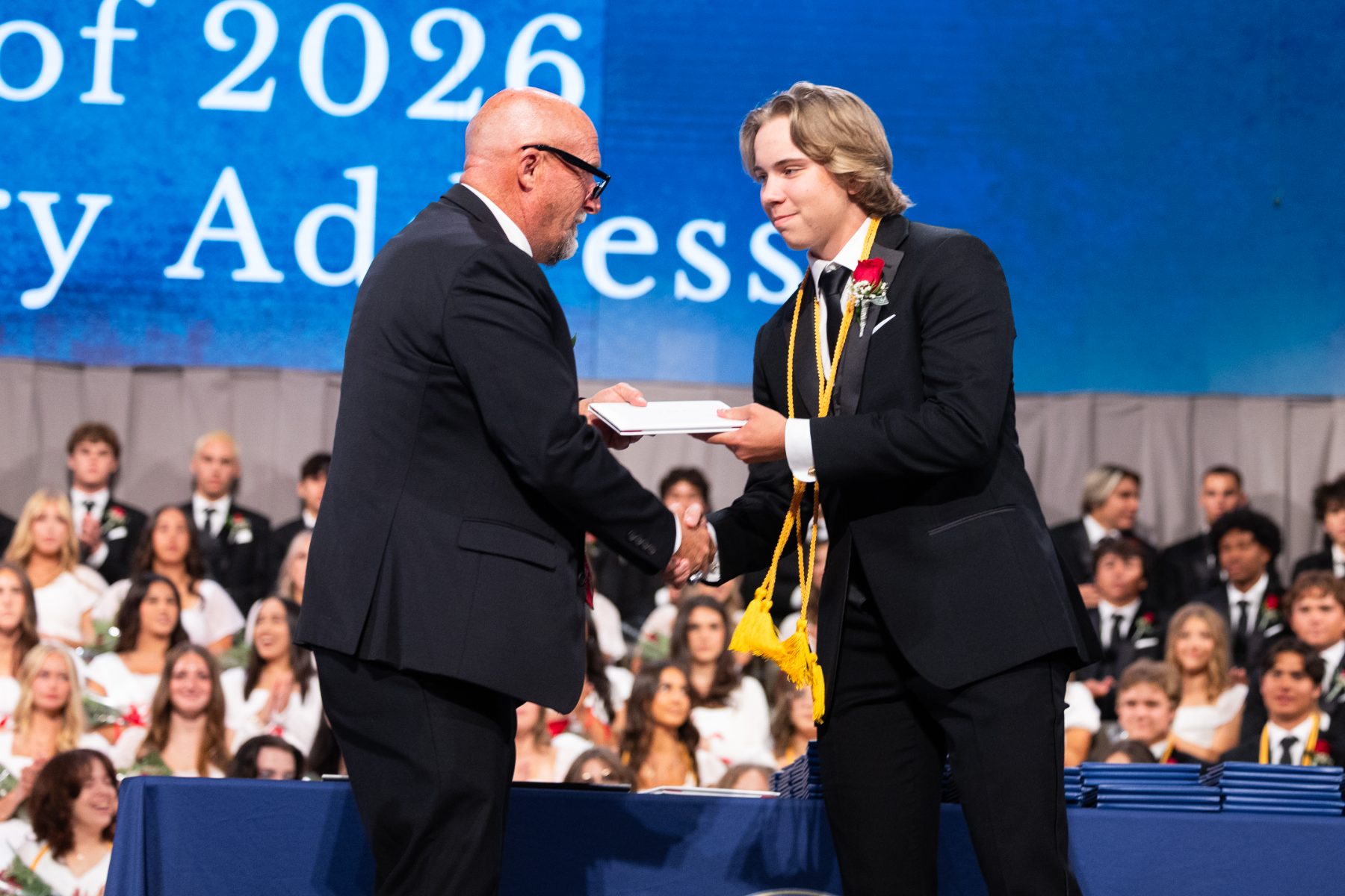 A Christian High School graduate receives his diploma on stage at Shadow Mountain.