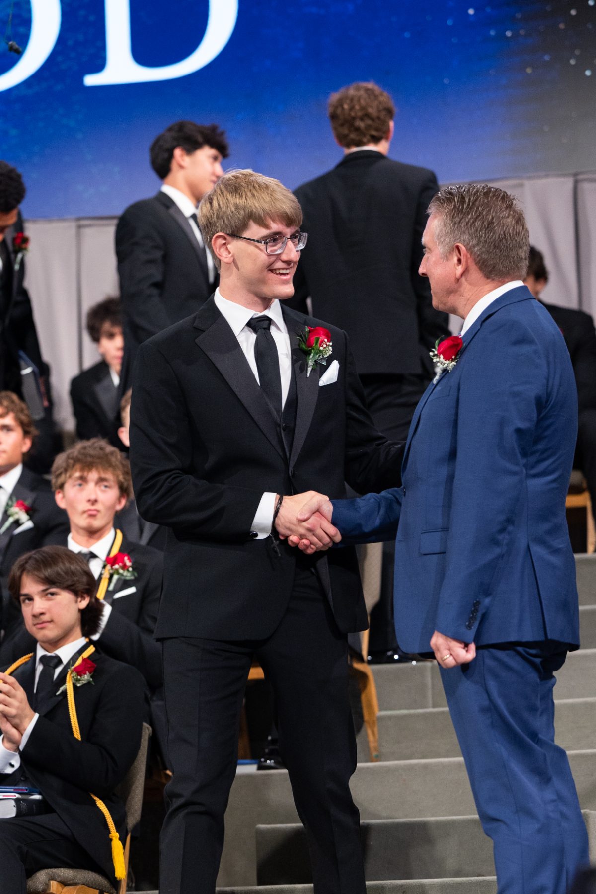 Christian High School graduate shakes hands with a man on stage at Shadow Mountain Church