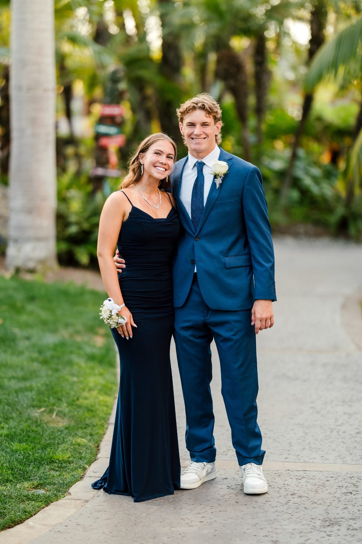 Couple dressed formally pose on path at Catamaran Resort banquet