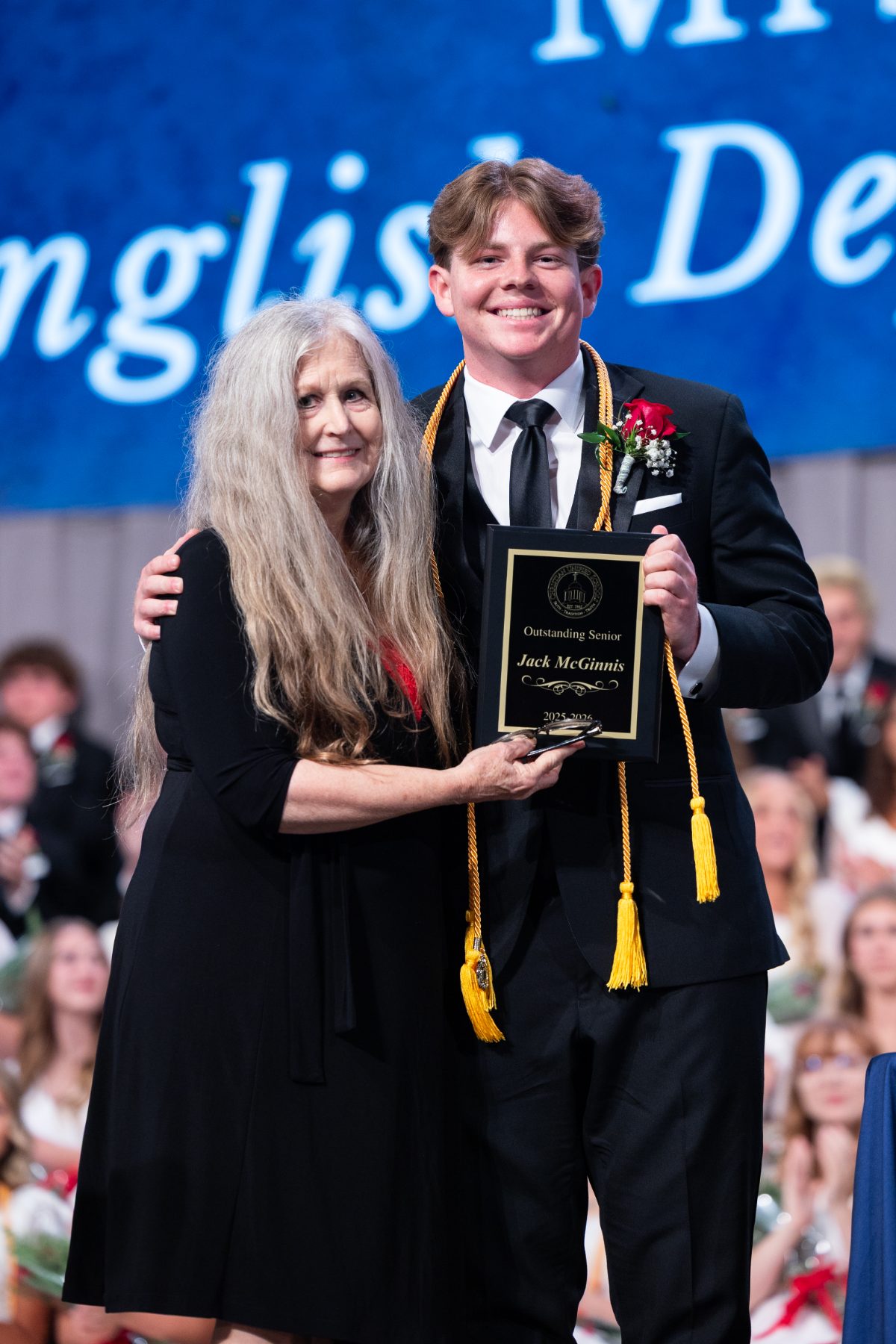 A teacher presents an English department plaque to a Christian High School graduate