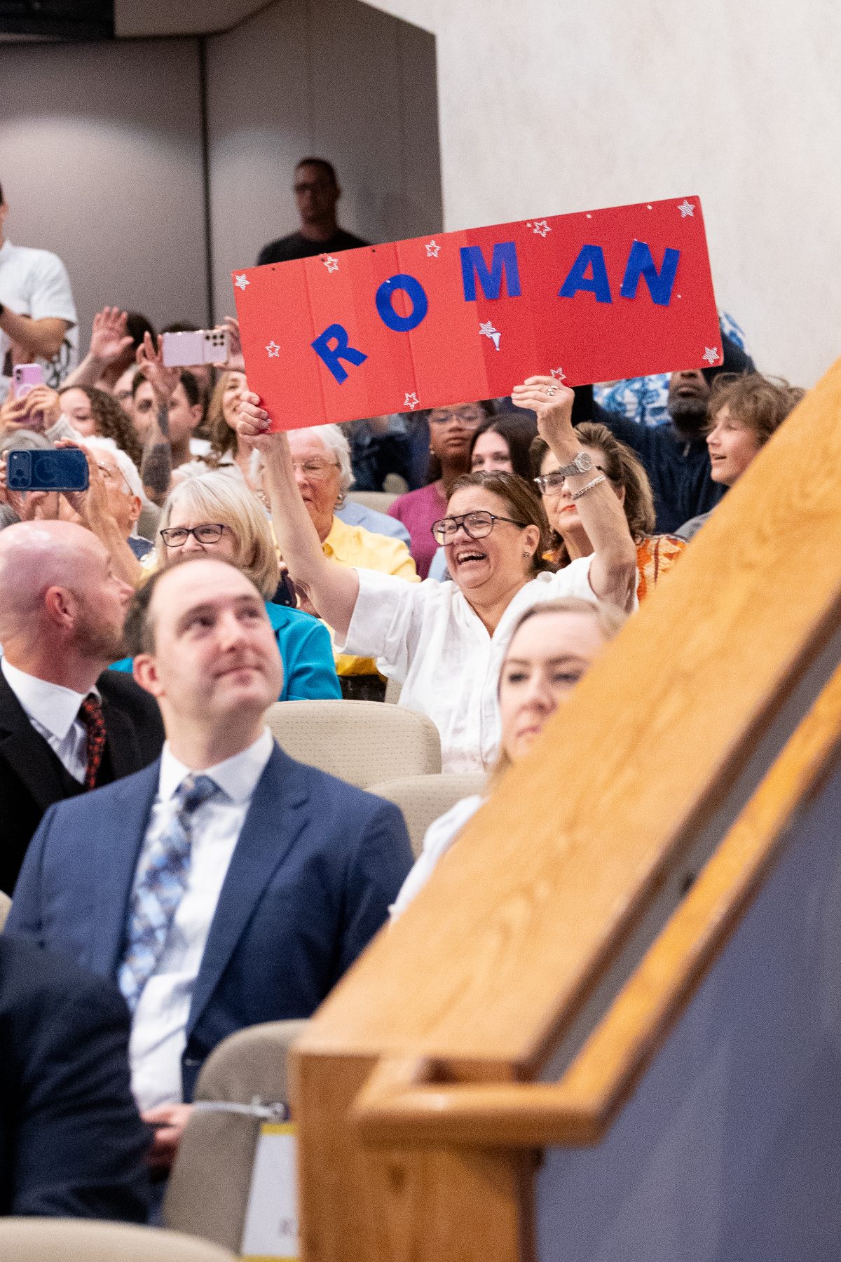 An audience member waves a red ROMAN sign during the CHS graduation ceremony
