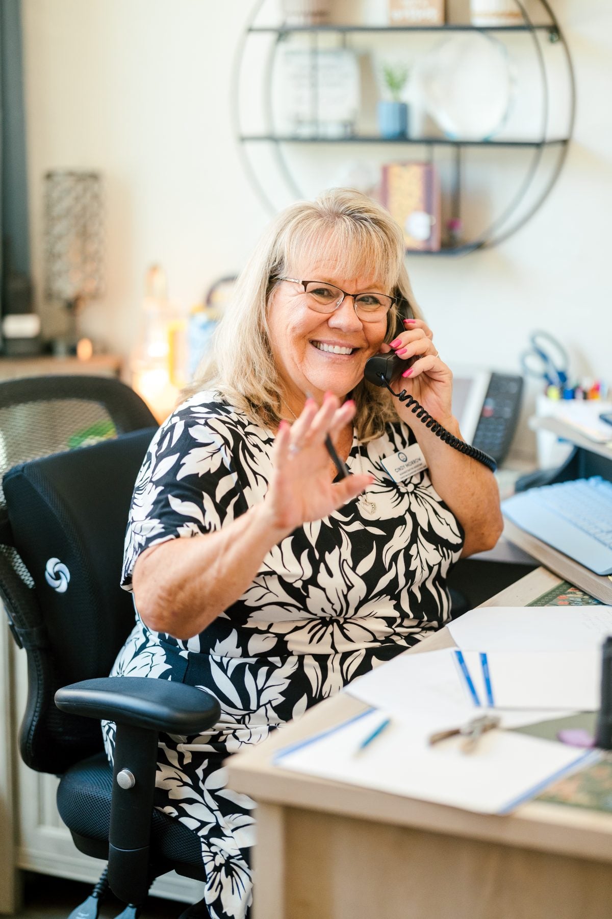 Front office staff member answers the phone with a friendly smile