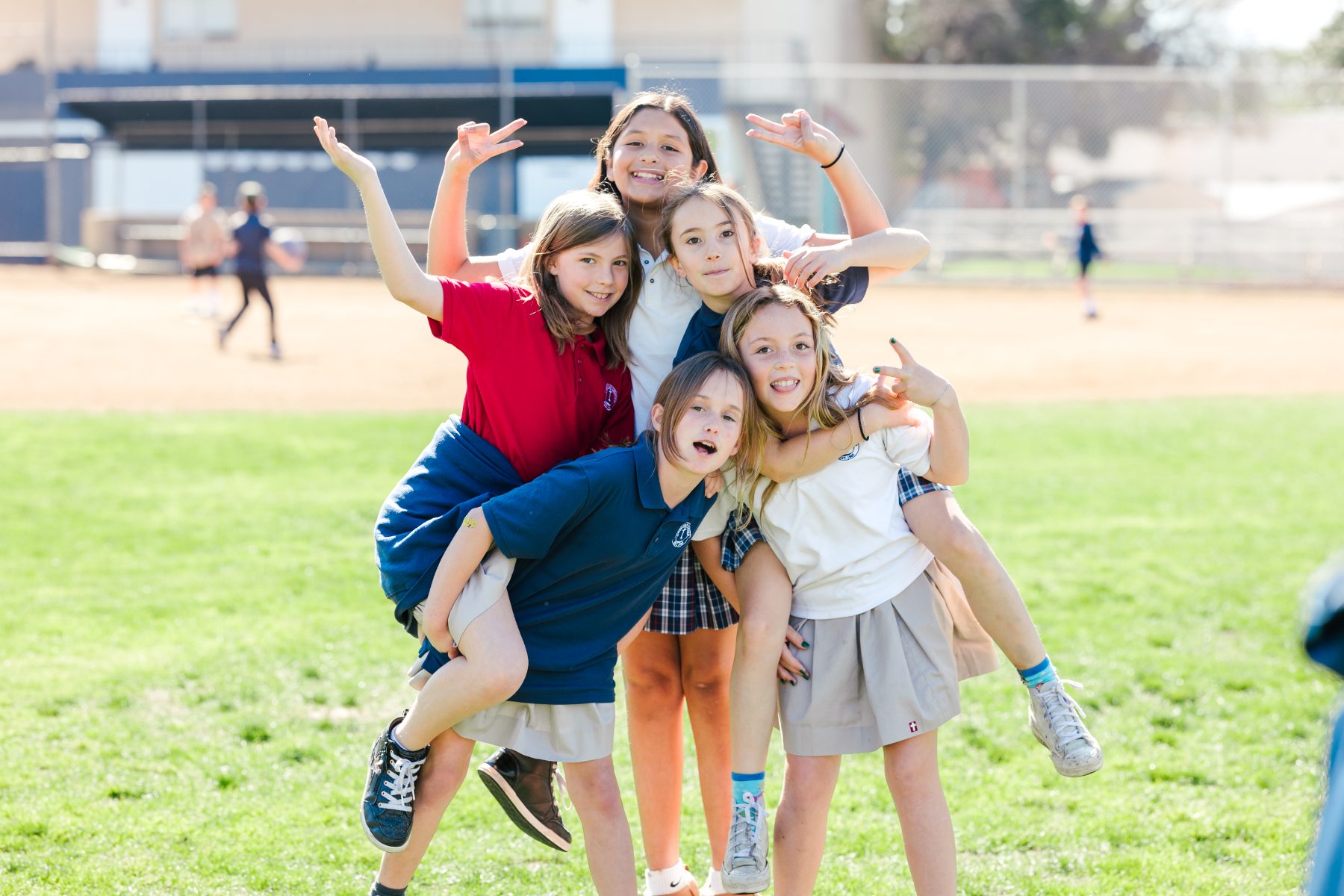 Five girls smile and pose together on the field at Christian Elementary School