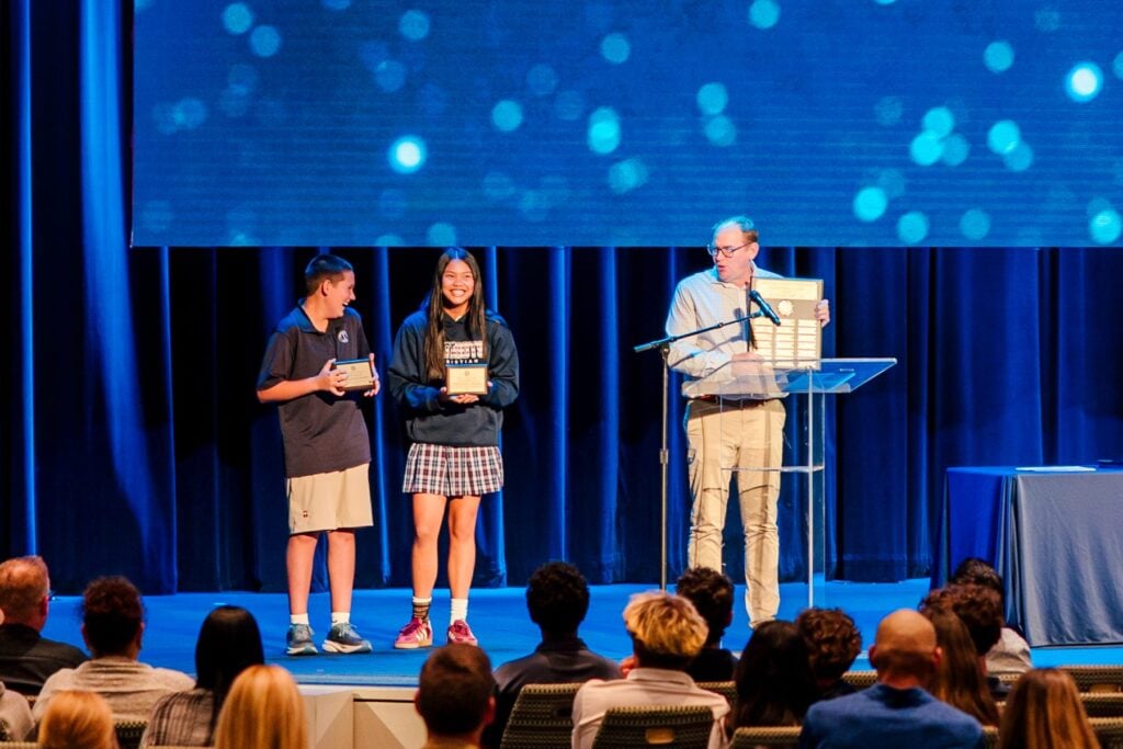 Junior high students receive academic awards on stage at Shadow Mountain Event Center.