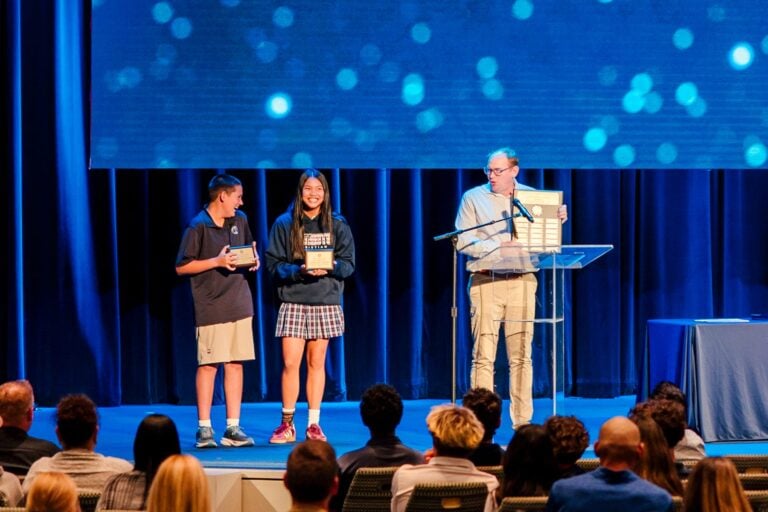 Junior high students receive academic awards on stage at Shadow Mountain Event Center.