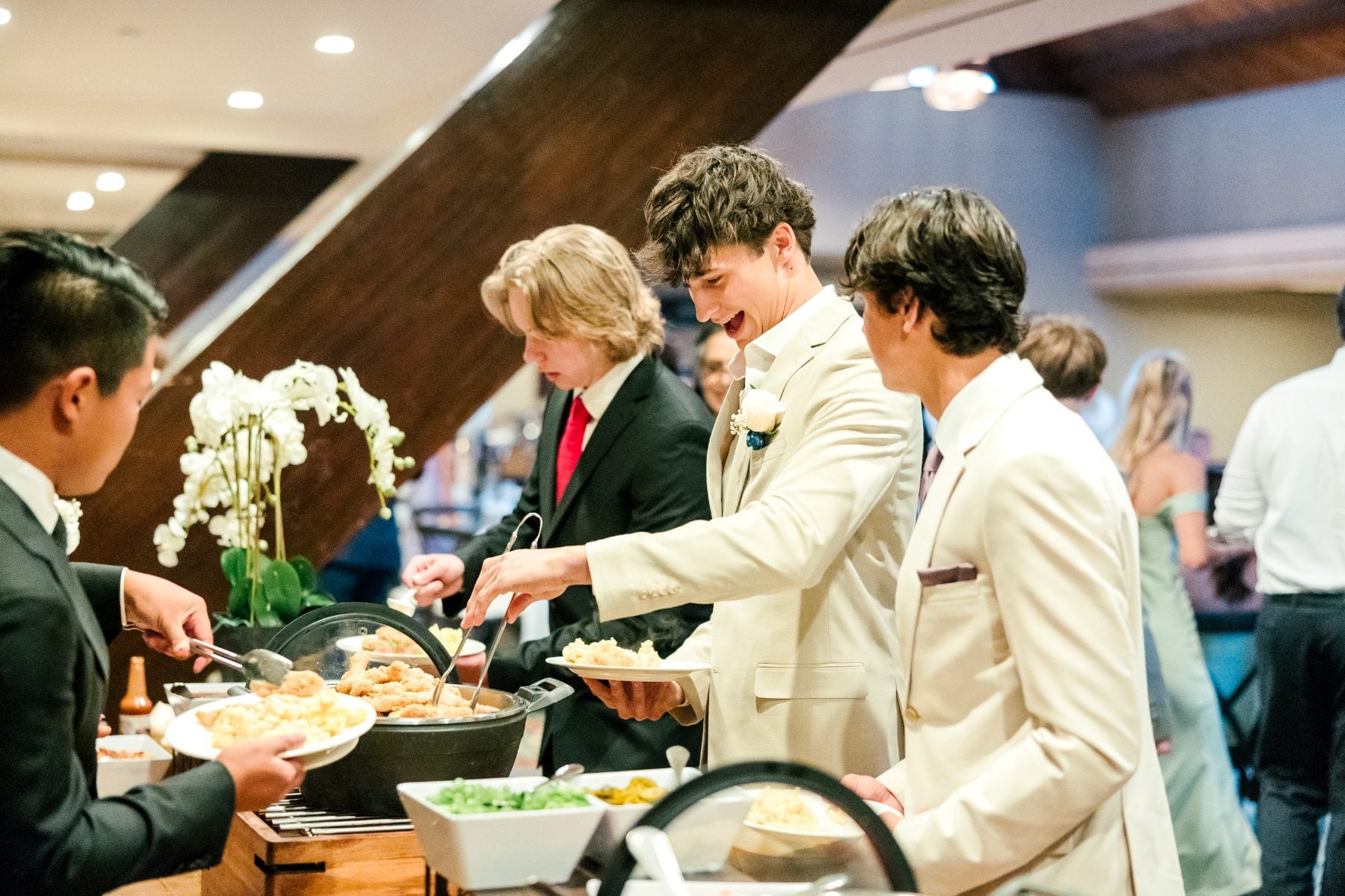 Students in formal wear serve themselves food at the buffet line