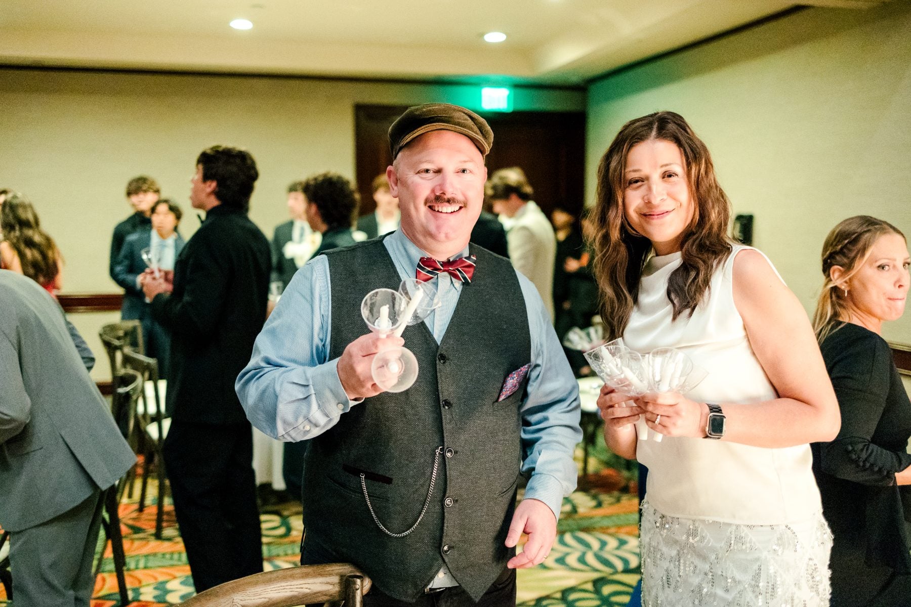 A man and woman smile holding sparkler glasses at the event
