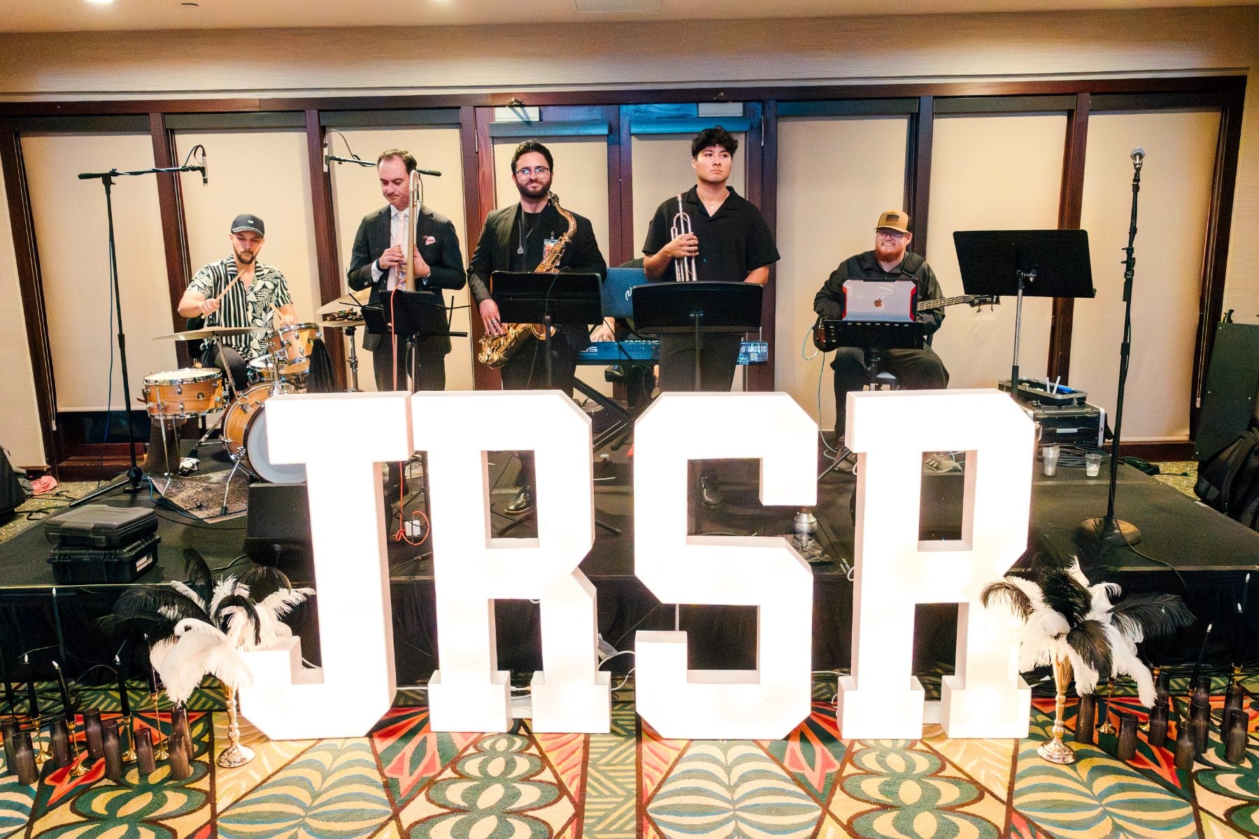 A live band performs beside lighted JRSR letters at the banquet