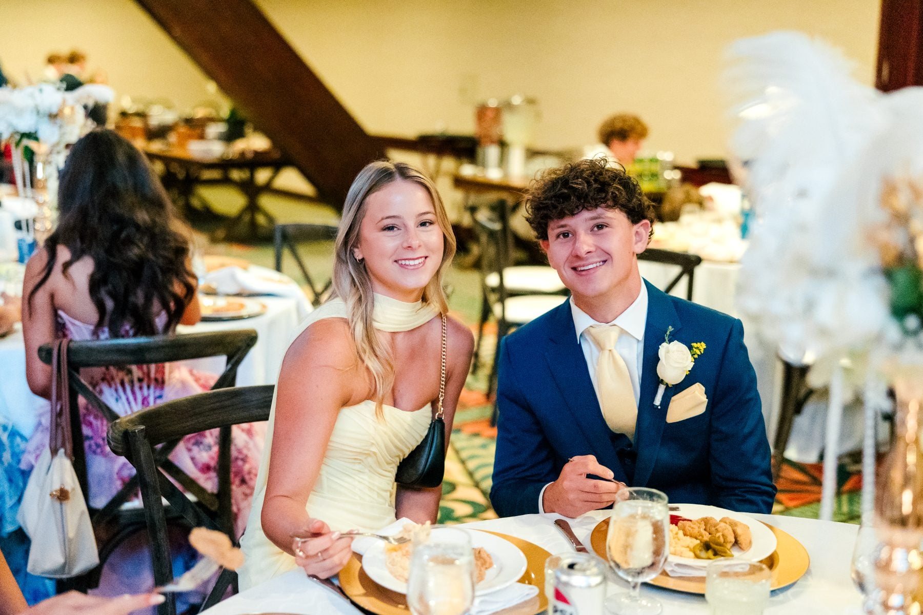A student couple smiles at their table during the Jr/Sr Banquet