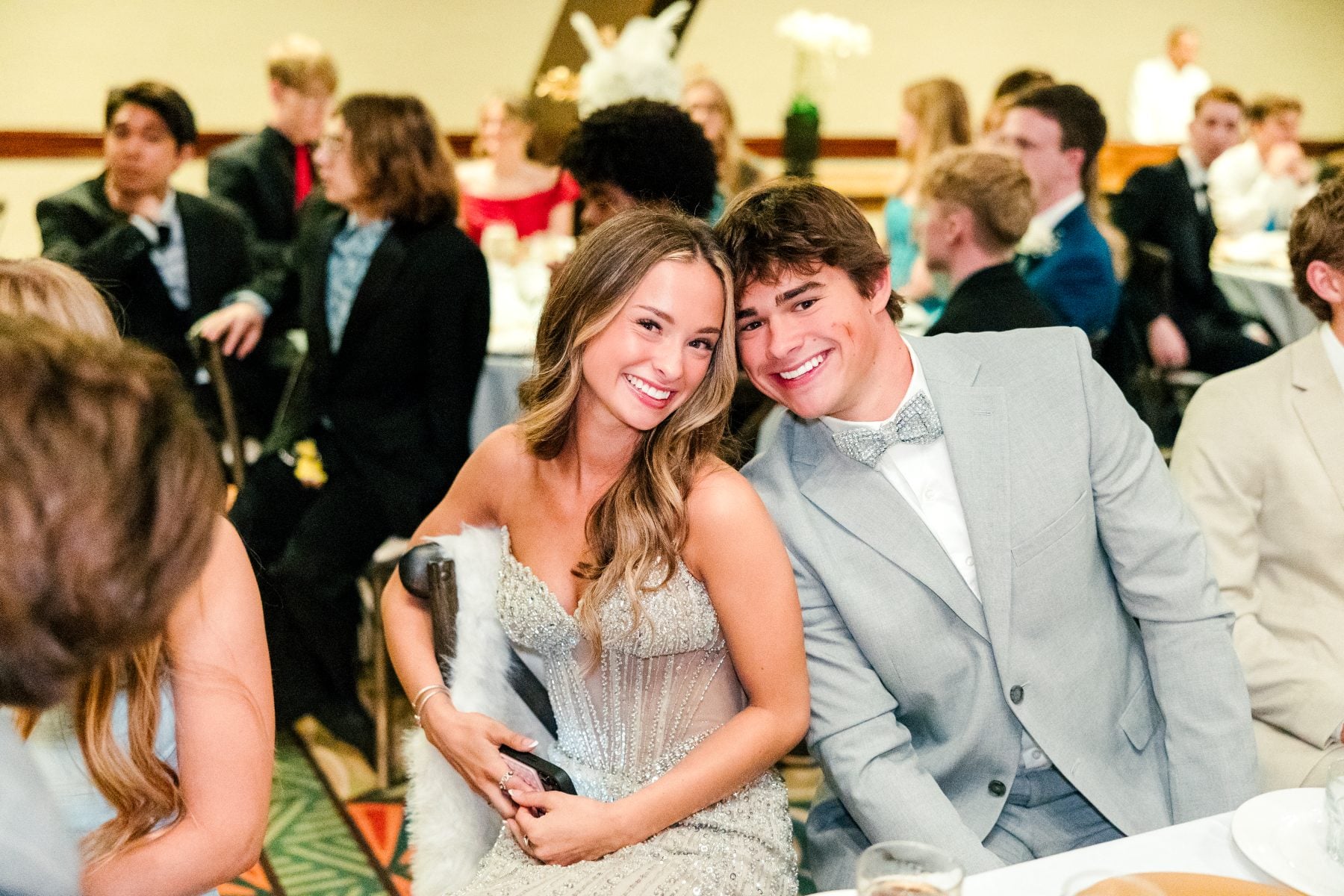 A student couple smiles together at the Catamaran Resort banquet