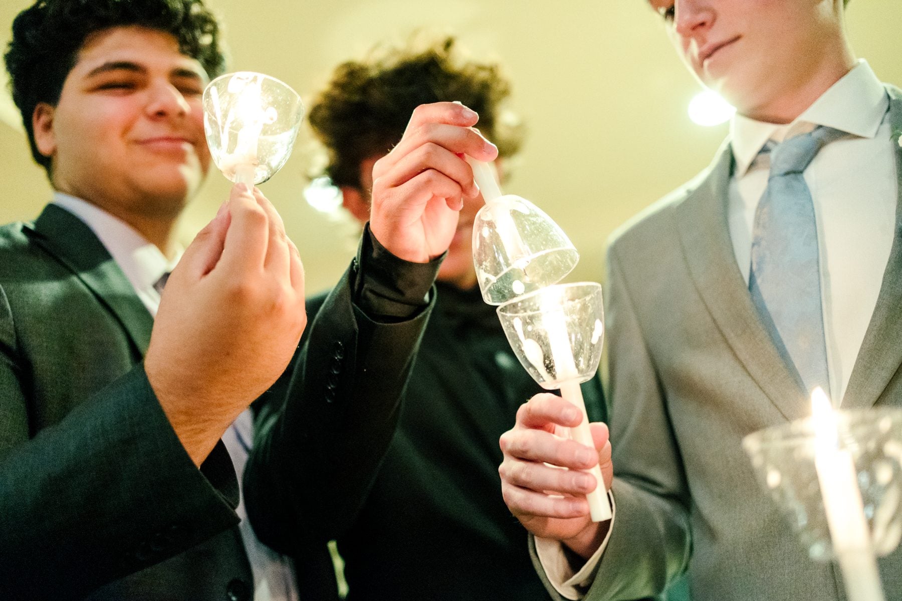 Students in suits hold sparkling glasses at the Jr/Sr Banquet