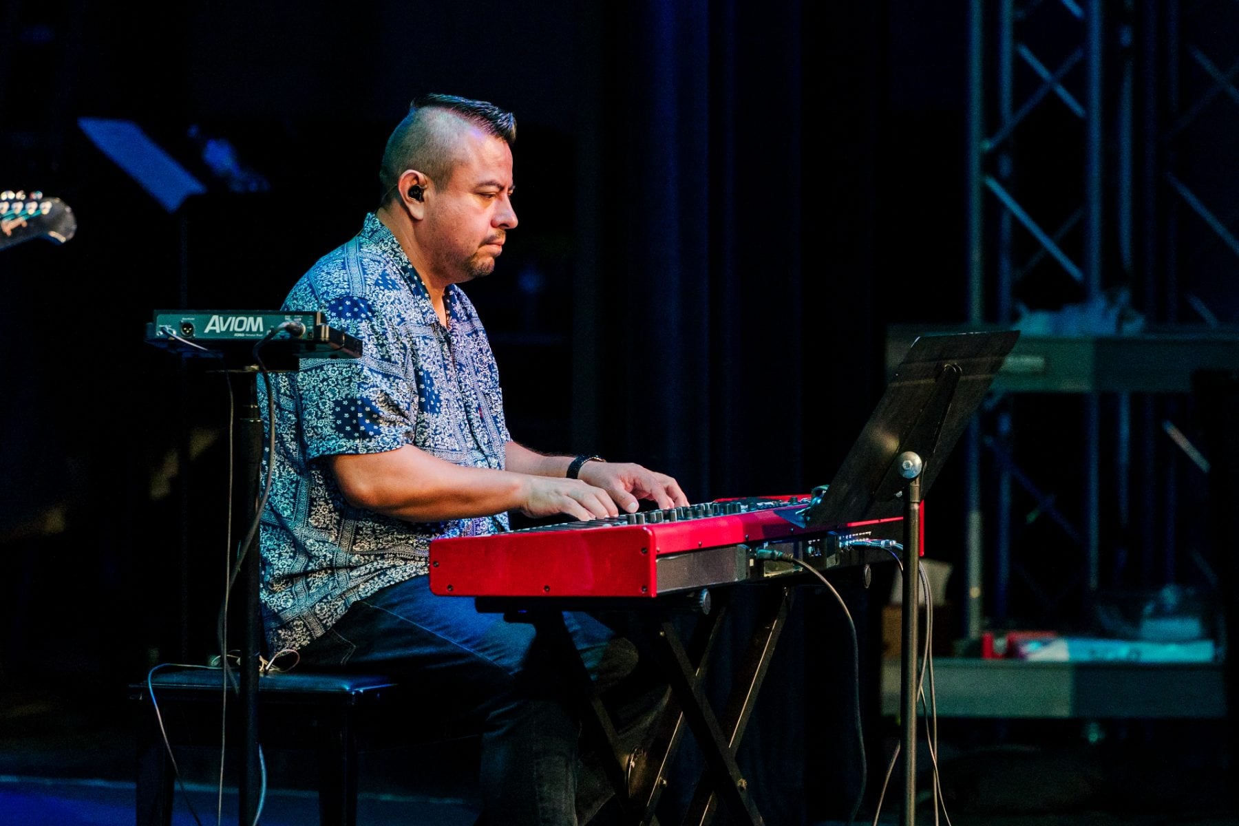 A musician playing keyboard on stage during the chapel service