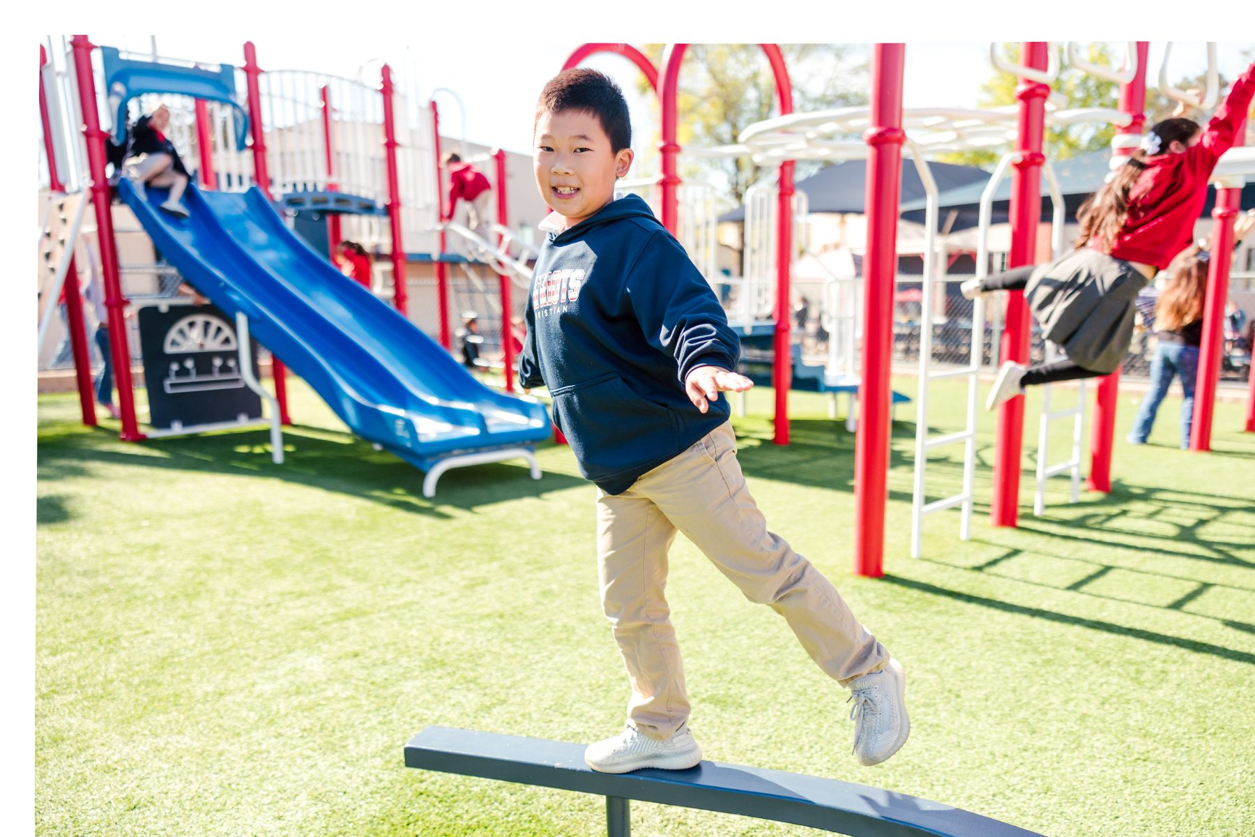 A student balances on a beam during recess at Christian Elementary School playground