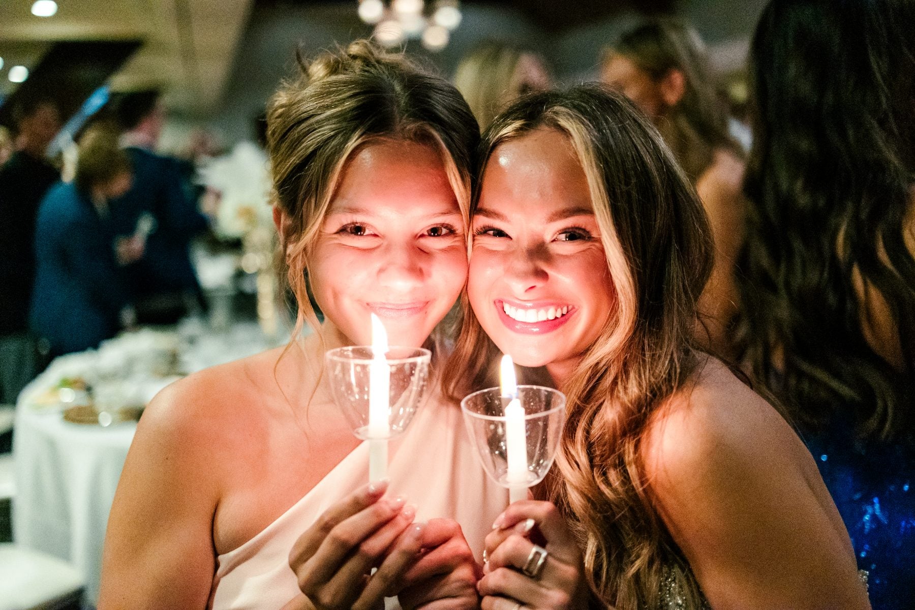Two students embrace holding lit candles at the Jr/Sr Banquet