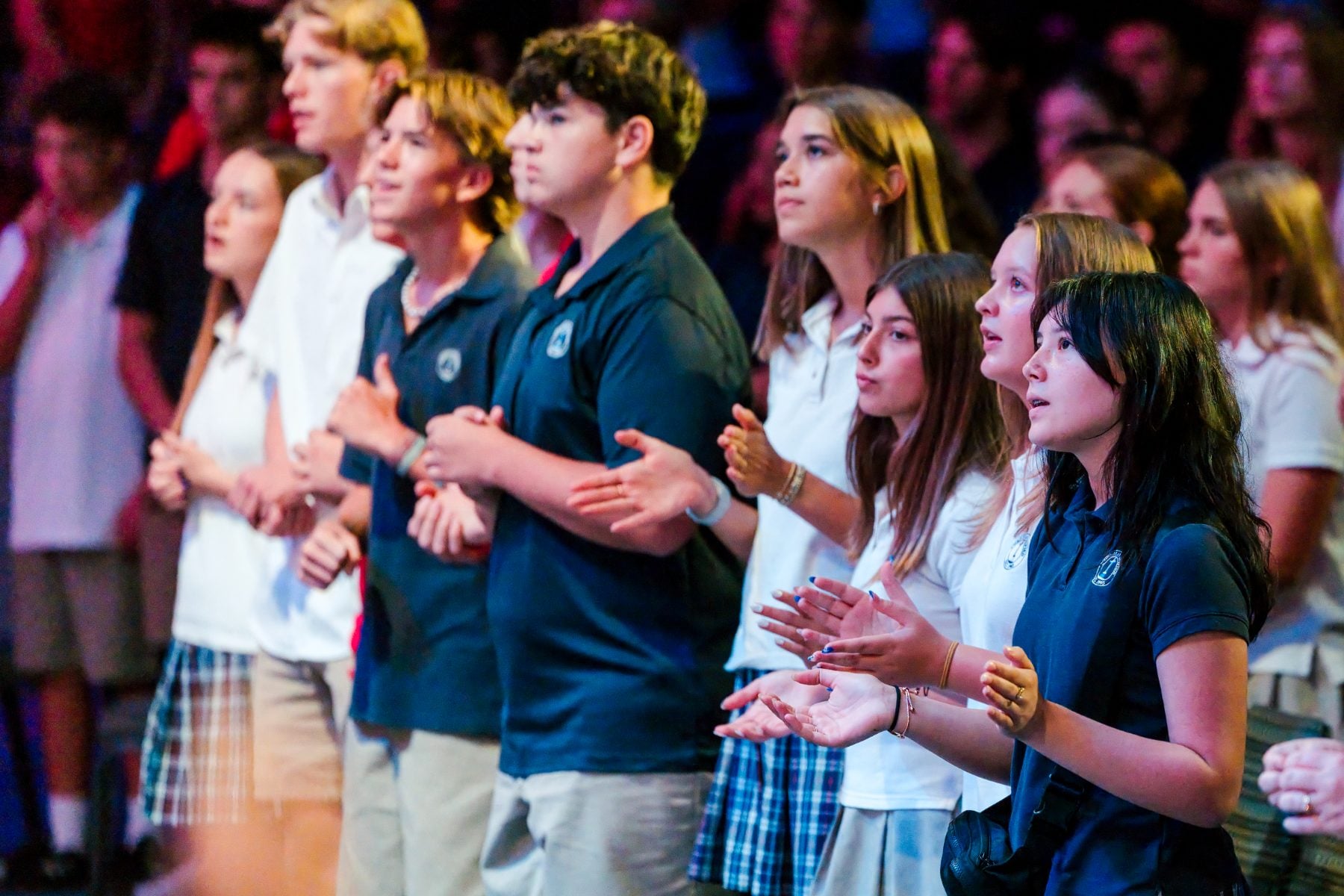 Students in uniform clap and sing during Walk Worthy Chapel kick-off