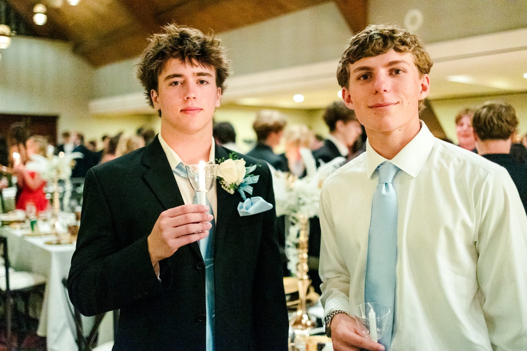 Two students in formalwear hold drinks together at the Jr/Sr Banquet