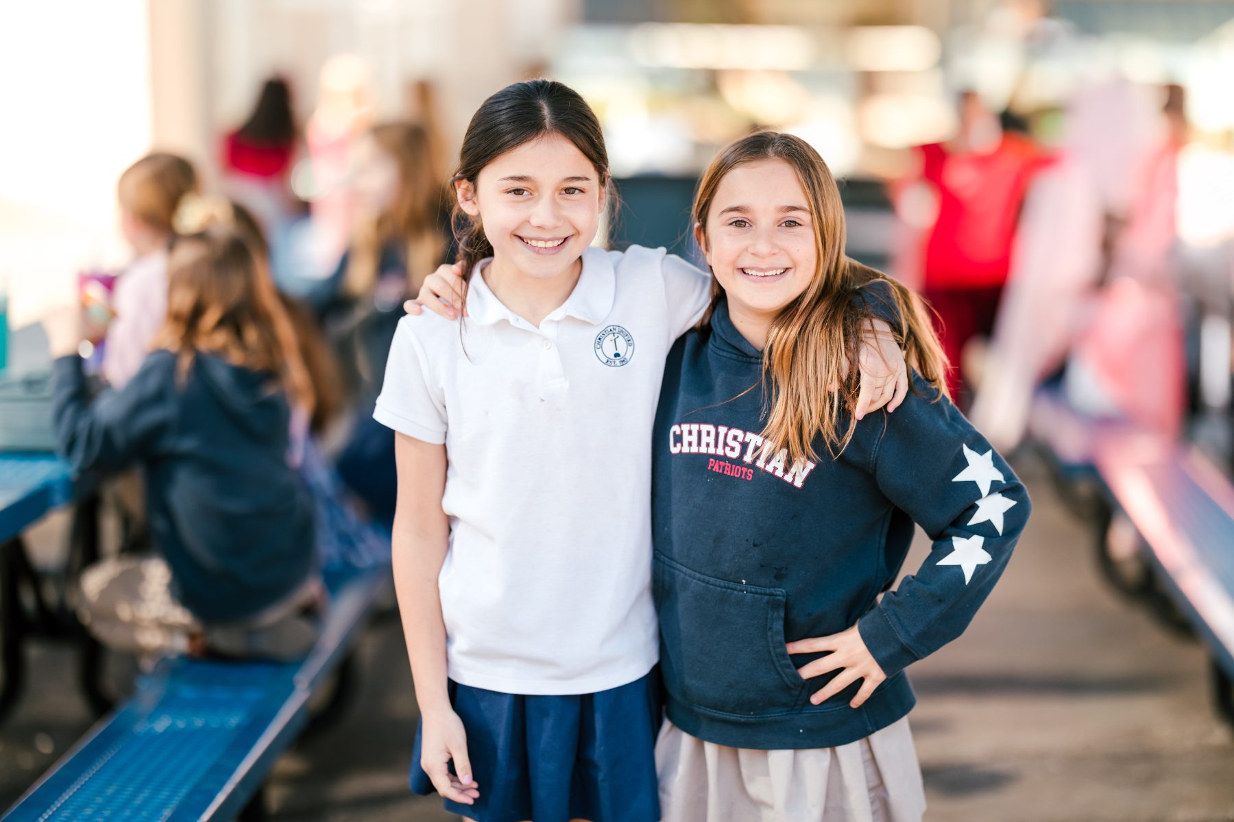 Two students embrace and smile outside at Christian Elementary School