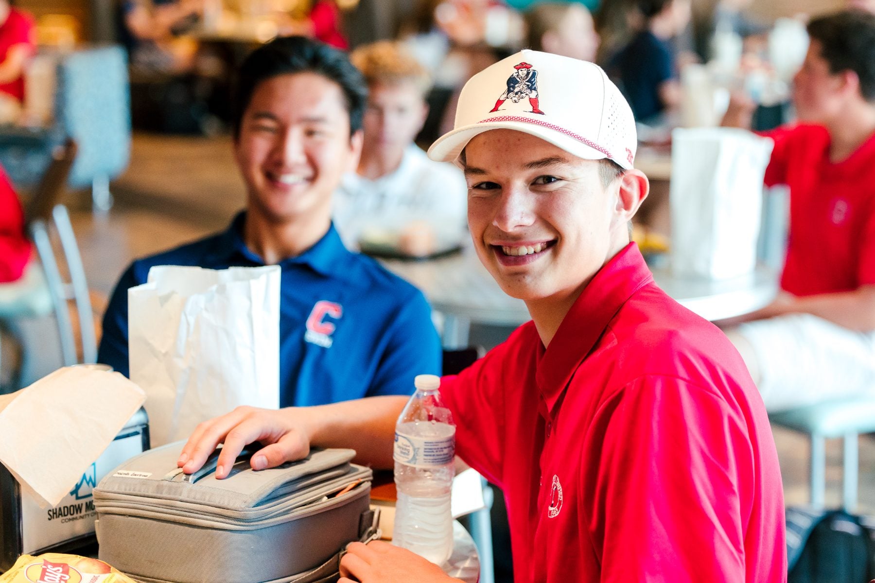 Two students smile at a lunch table during the campus BBQ event