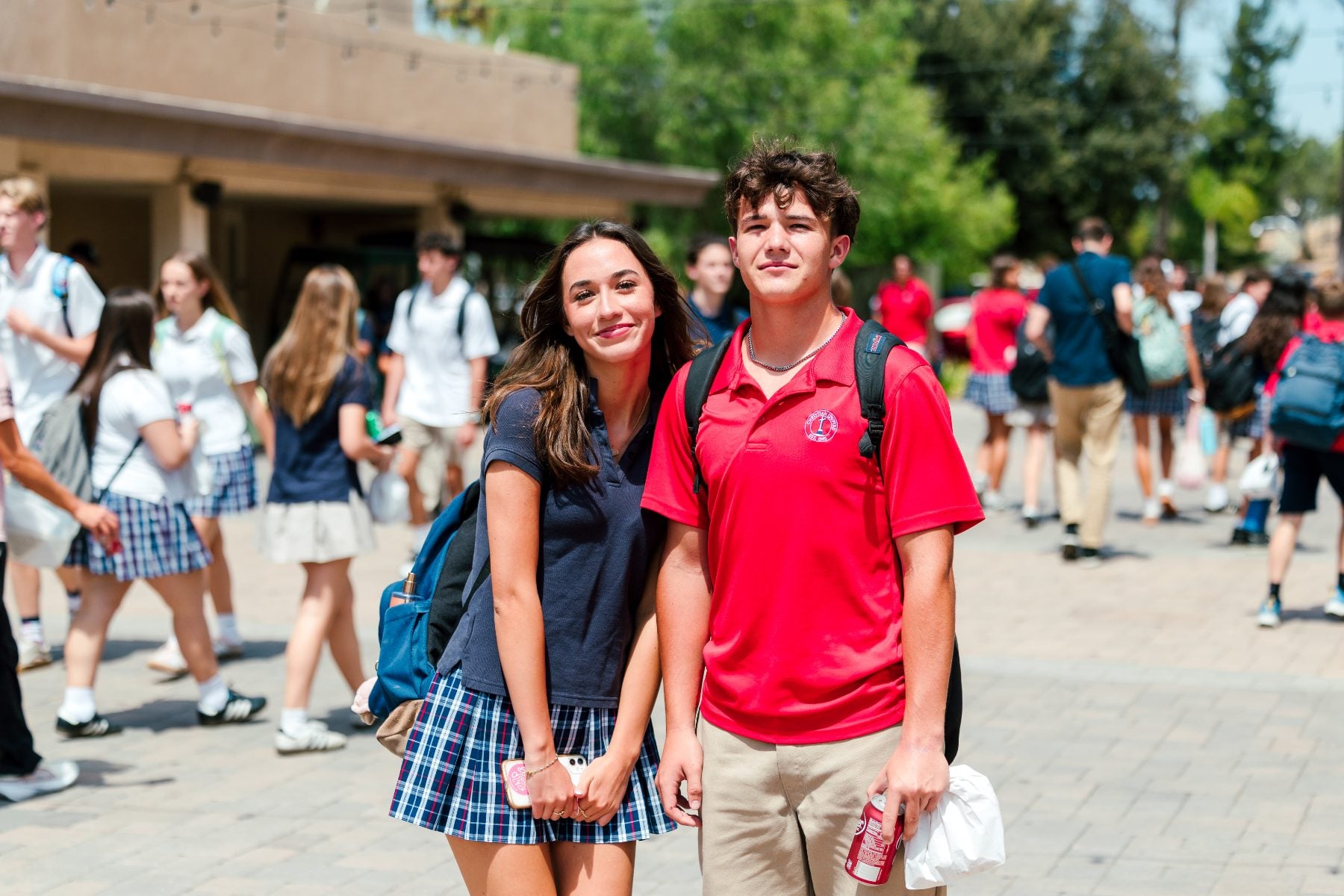 A Christian school student pair pose outside as classmates pass by