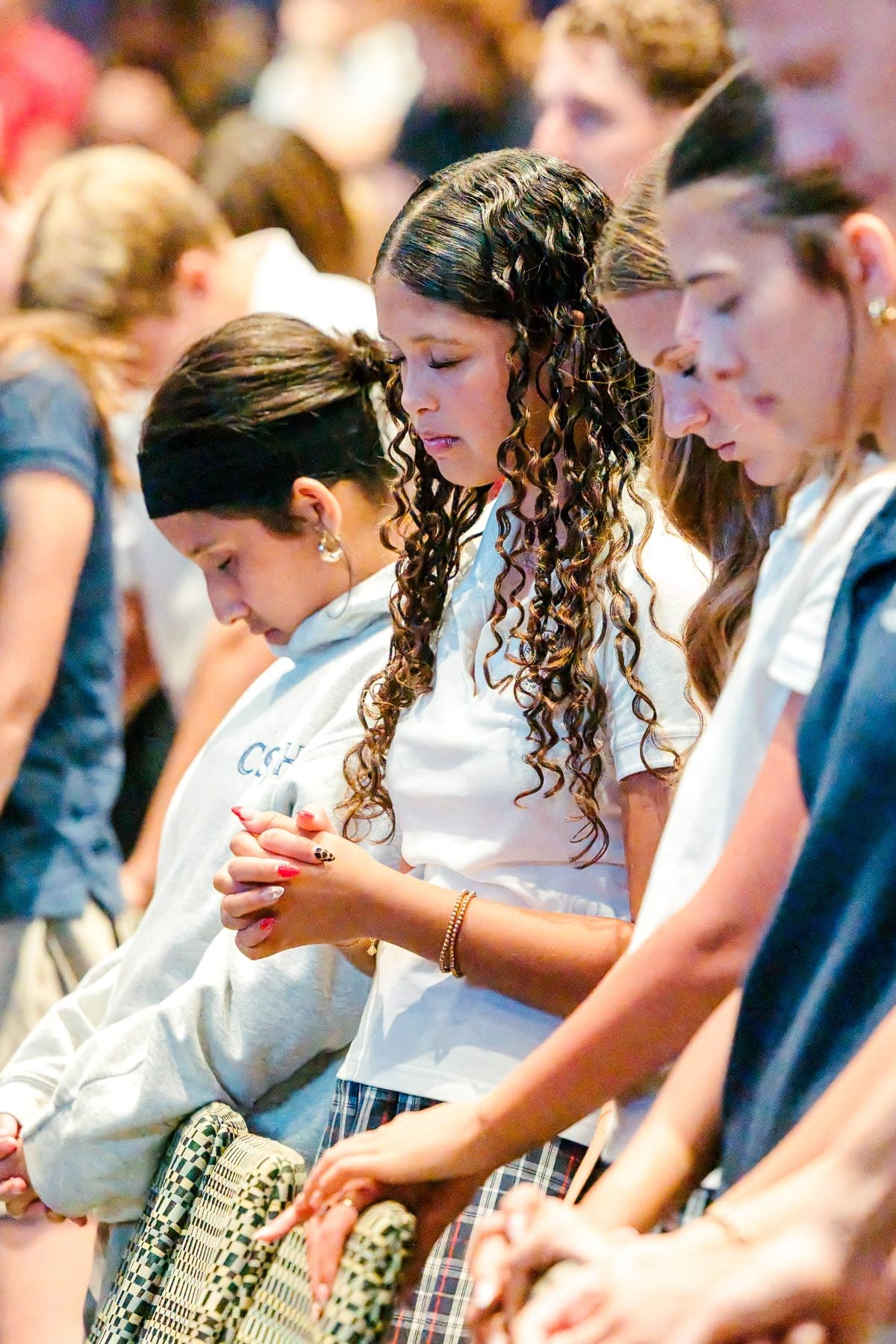 Students bowing their heads in prayer during Walk Worthy Chapel