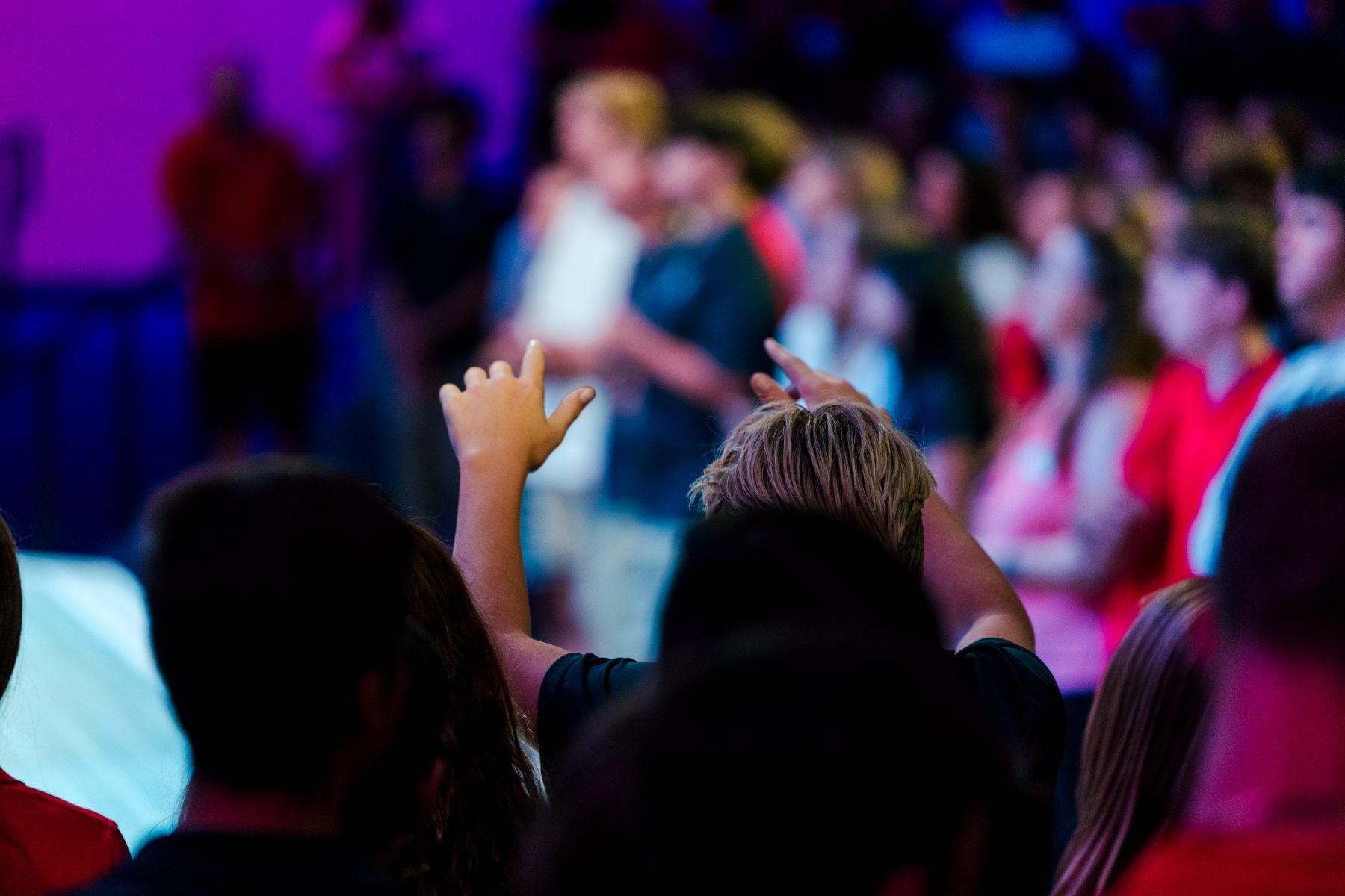 Students raise hands in worship during Walk Worthy Chapel at Event Center