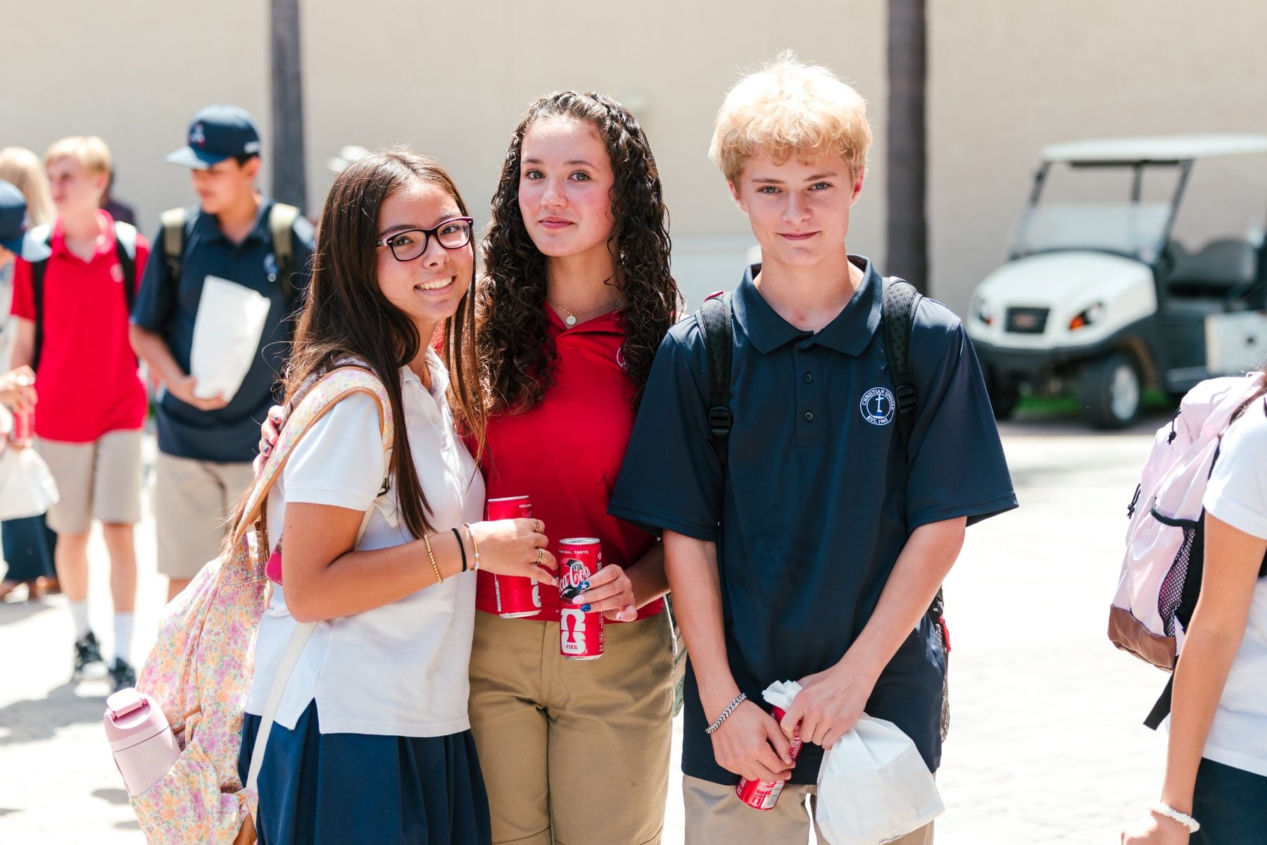 Three Christian High School Patriots students smile together at the BBQ event