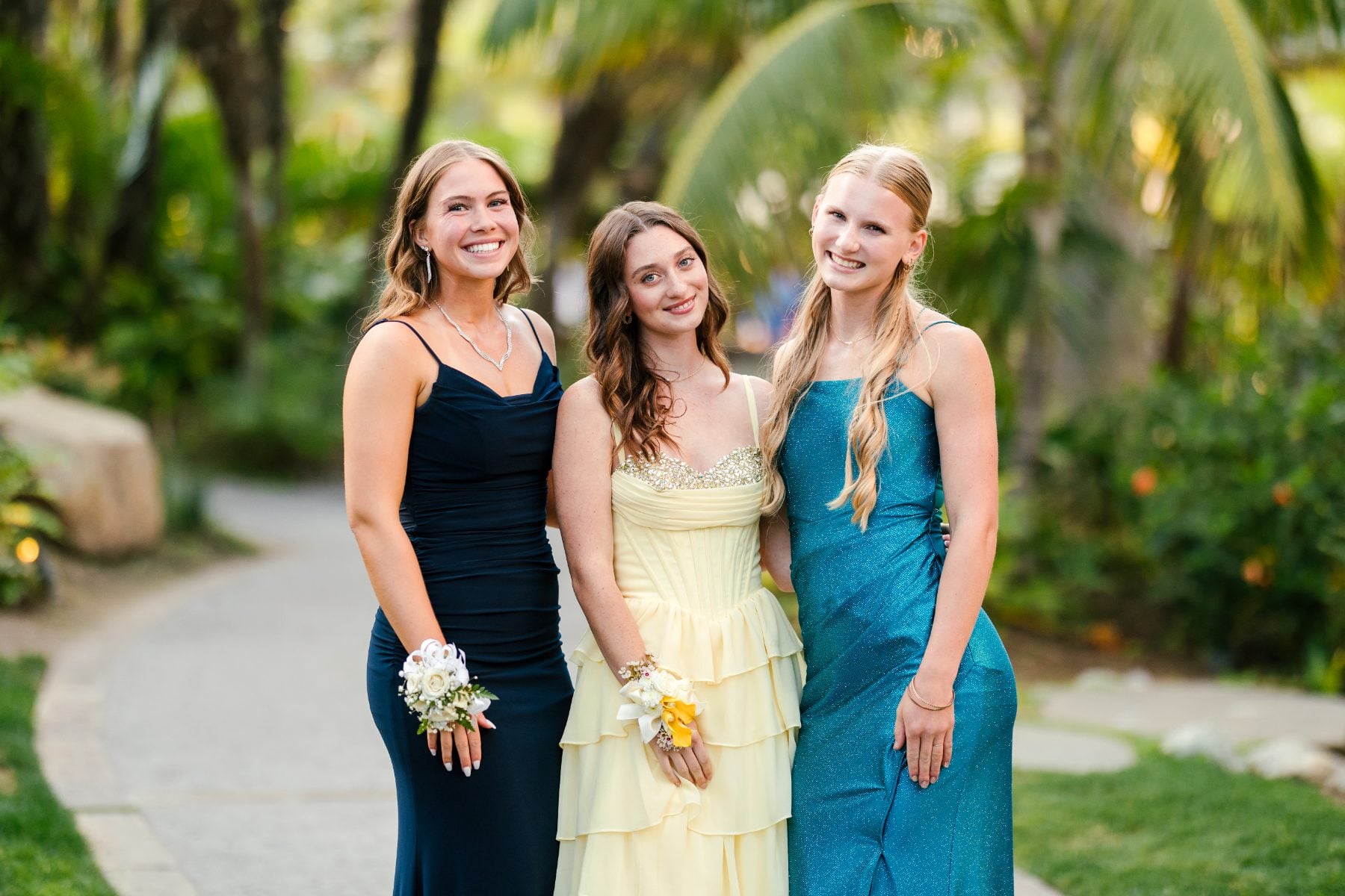 Three students in prom dresses smile together, Christian school student life