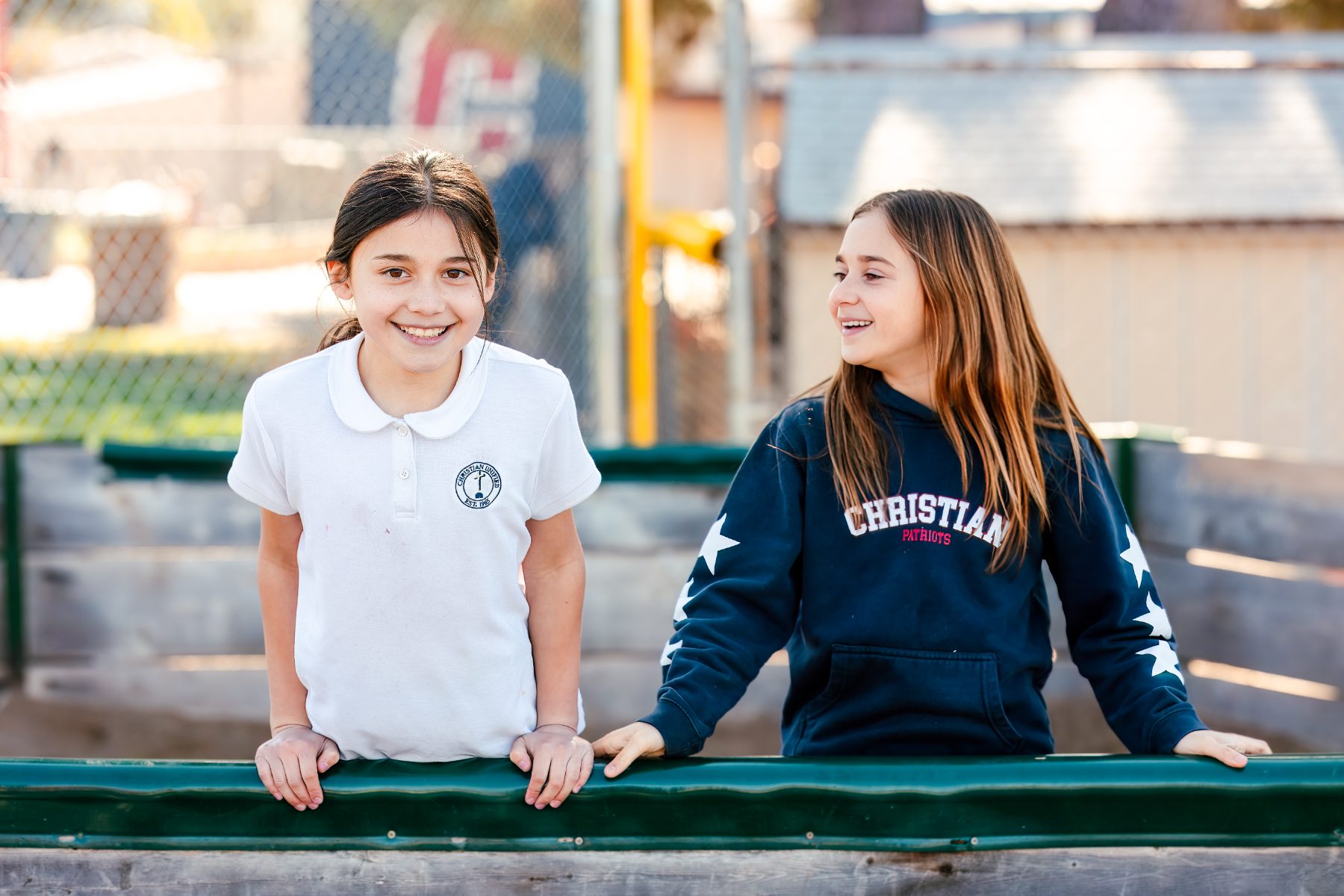 Two girls chat while sitting on a bench at Christian Elementary School