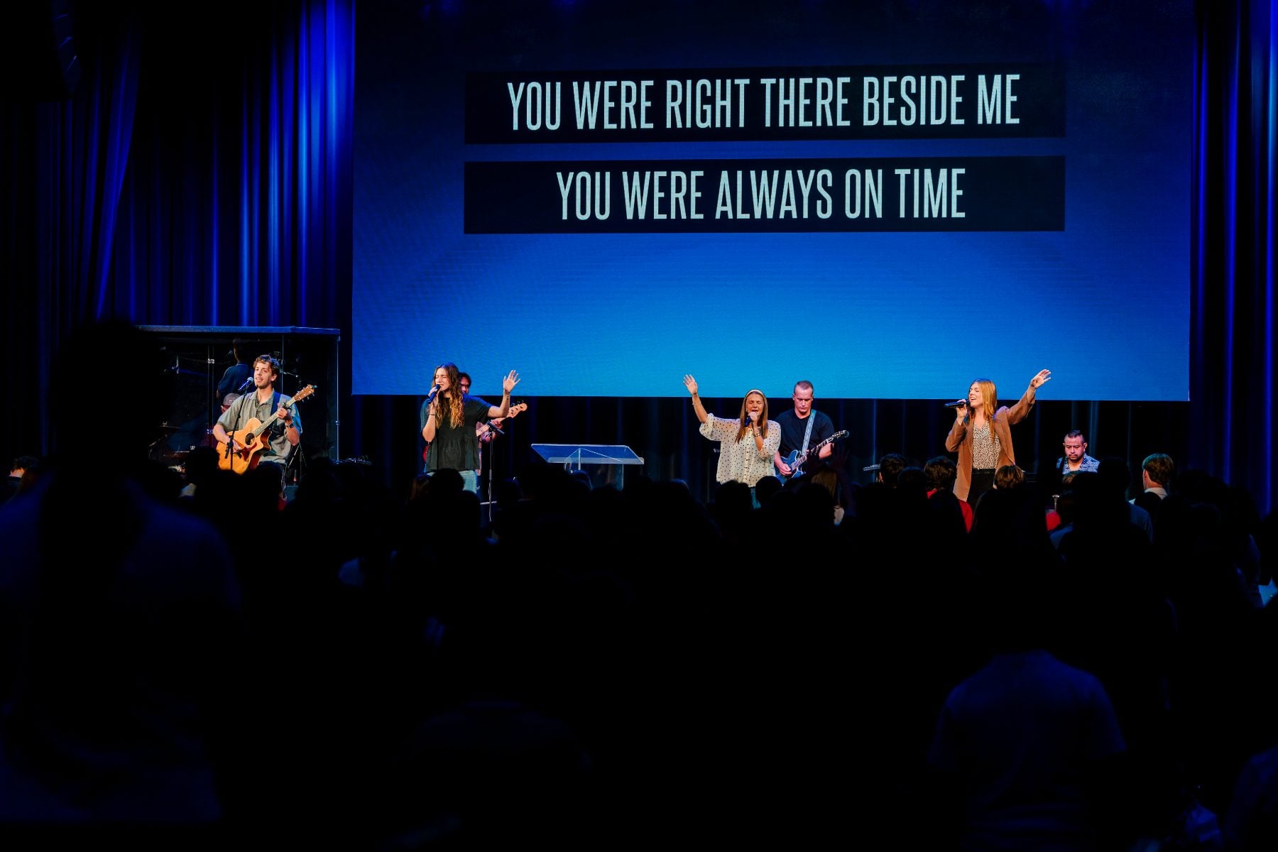 Worship band leads chapel with lyrics on screen at Shadow Mountain Event Center
