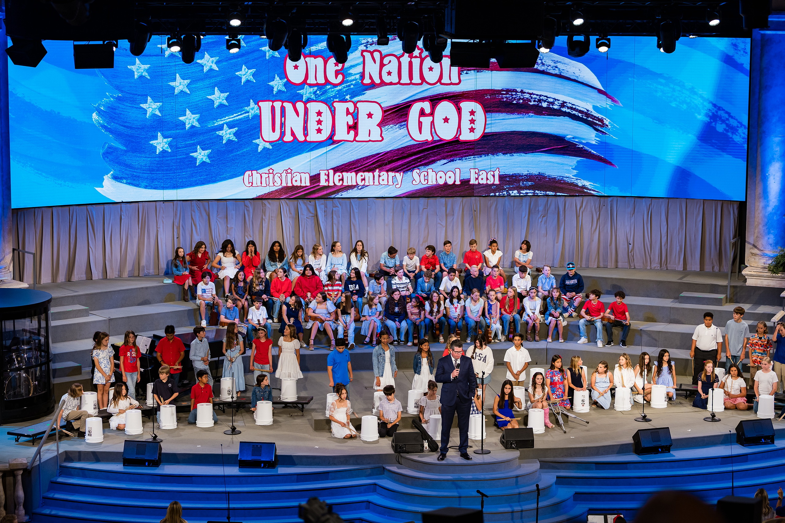 Christian Elementary East Celebrates Spring with “One Nation Under God” — 01 Full cast of elementary students standing on stage for One Nation Under God program
