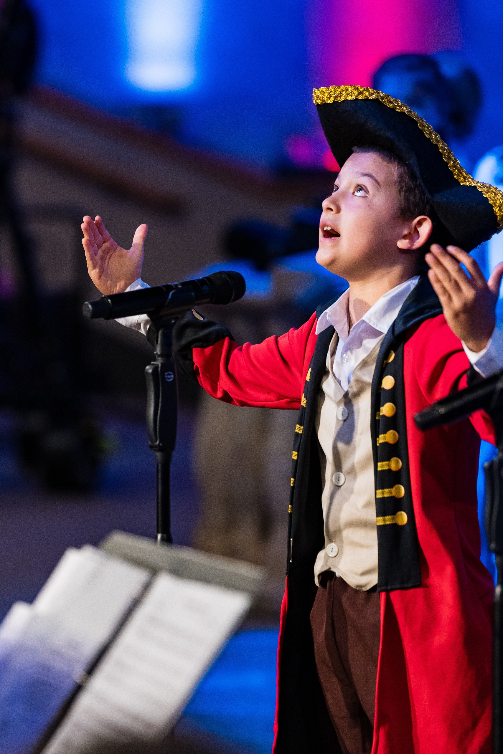 Christian Elementary East Celebrates Spring with “One Nation Under God” — 05 Student in colonial founding father costume singing at microphone