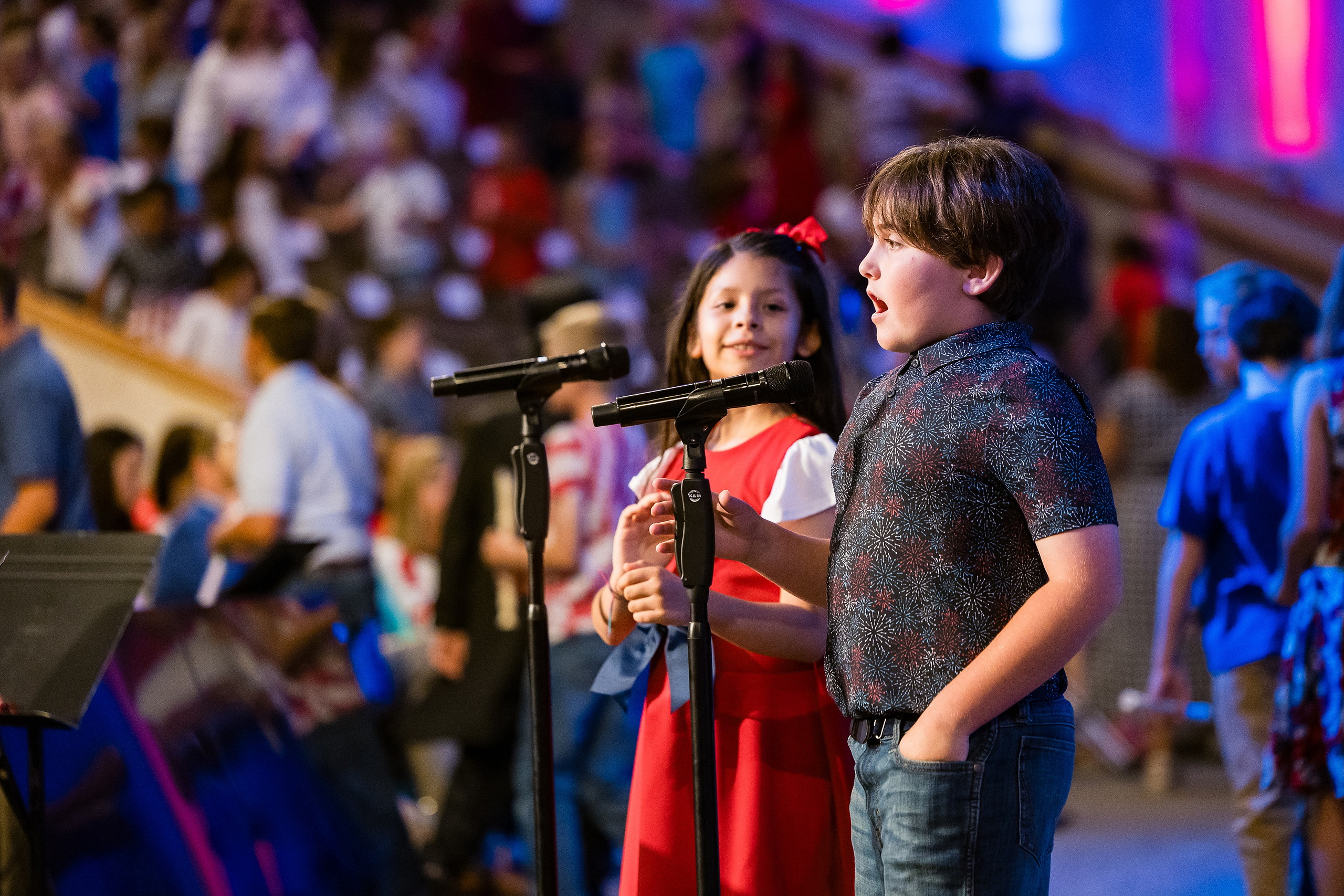 Christian Elementary East Celebrates Spring with “One Nation Under God” — 15 Two students of different ages singing duet at microphone together