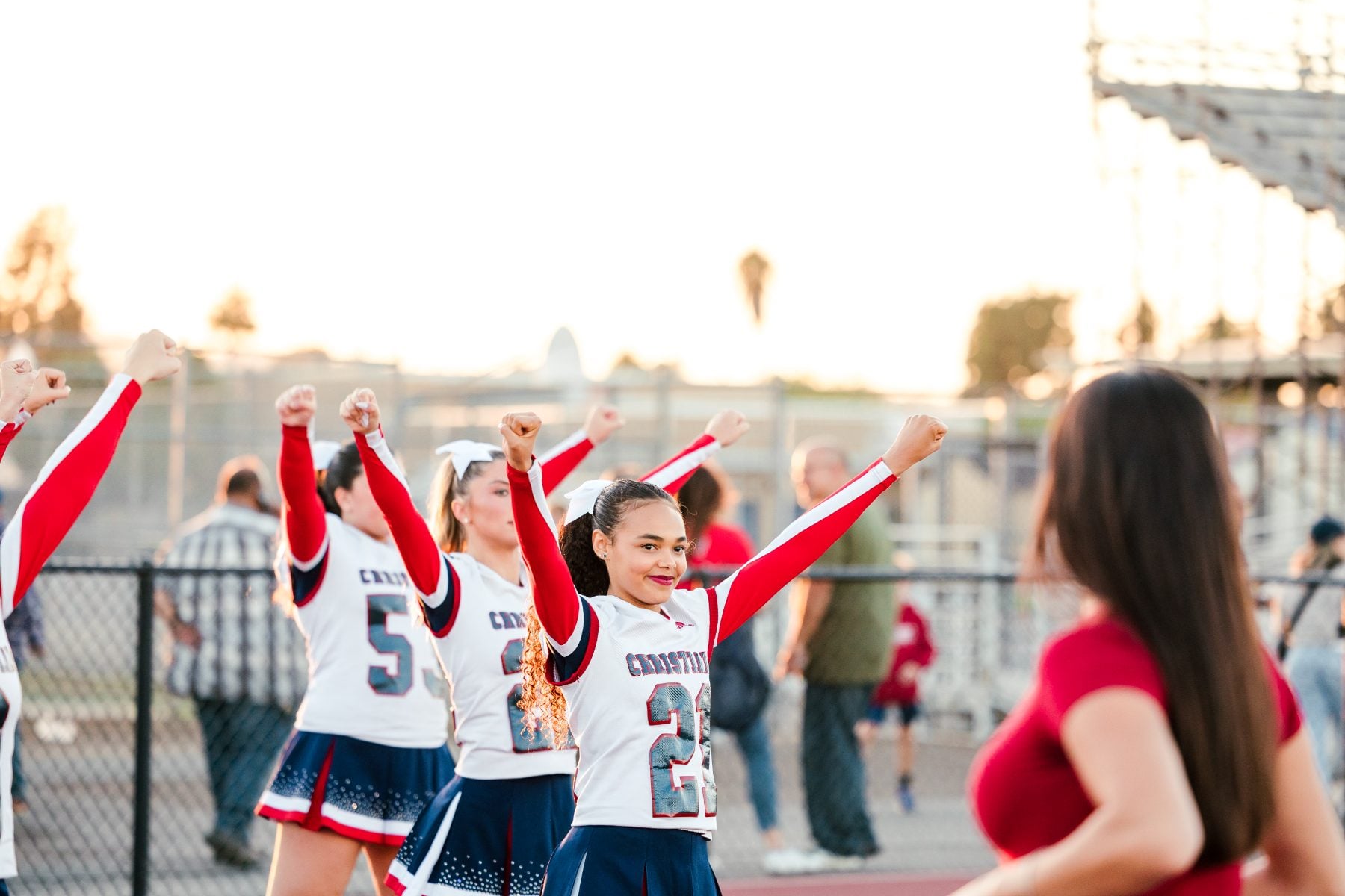 Cheerleaders cheer enthusiastically on the field at Christian High School homecoming game