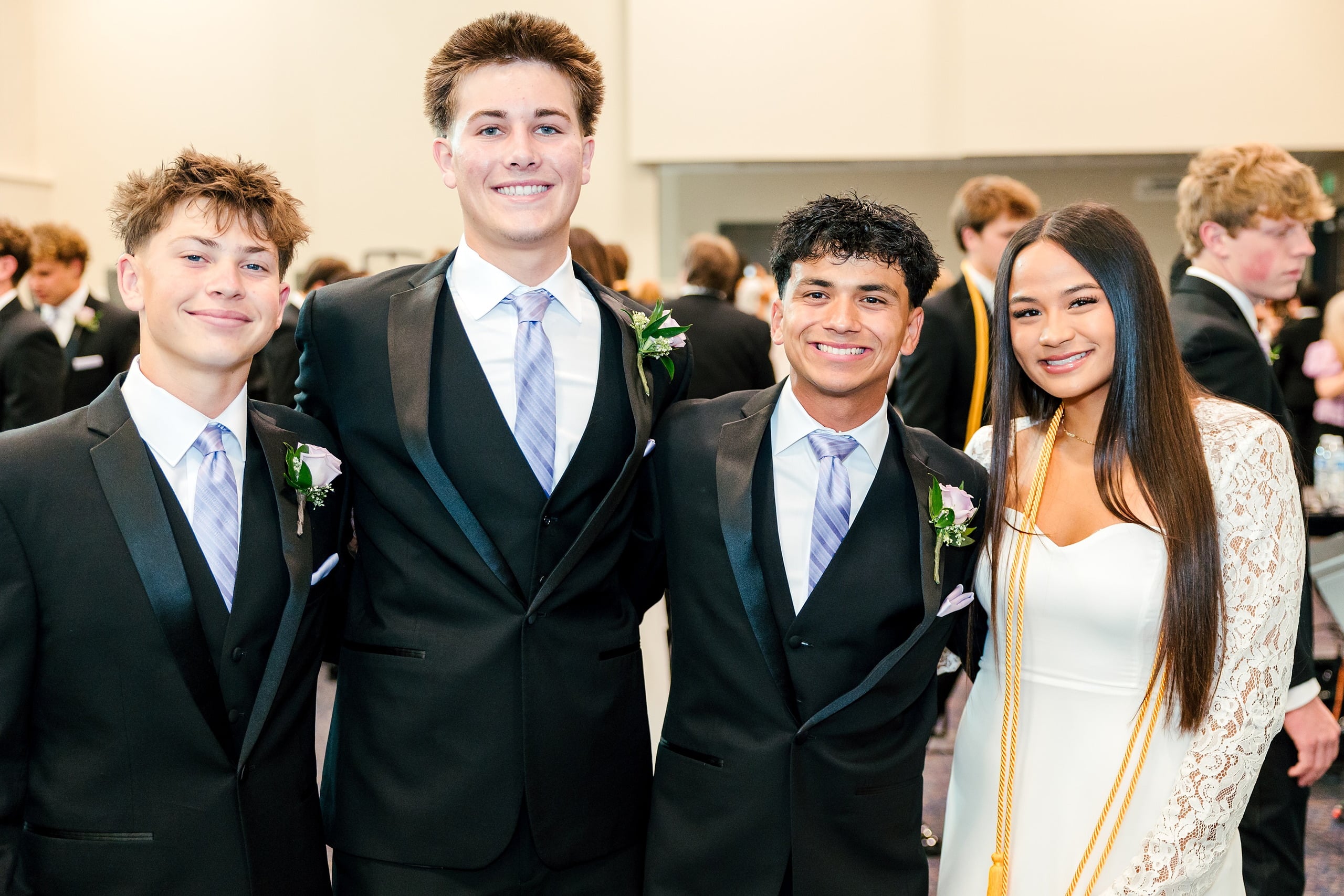 Christian High School Commencement 2025: Rise Up — 04 Three male and one female graduate stand together in formal commencement attire