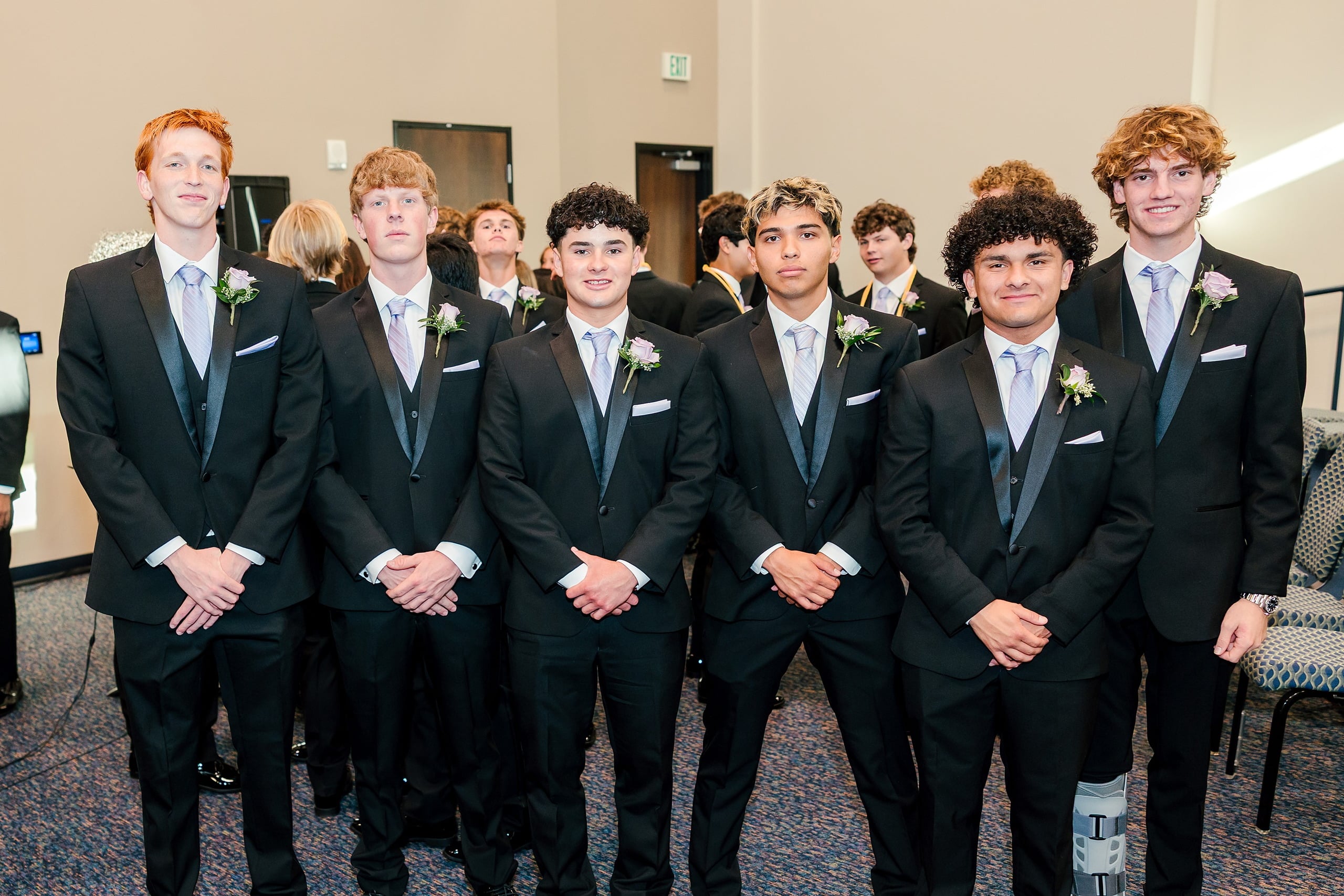 Christian High School Commencement 2025: Rise Up — 09 Six male graduates in black suits stand in a line with hands clasped together