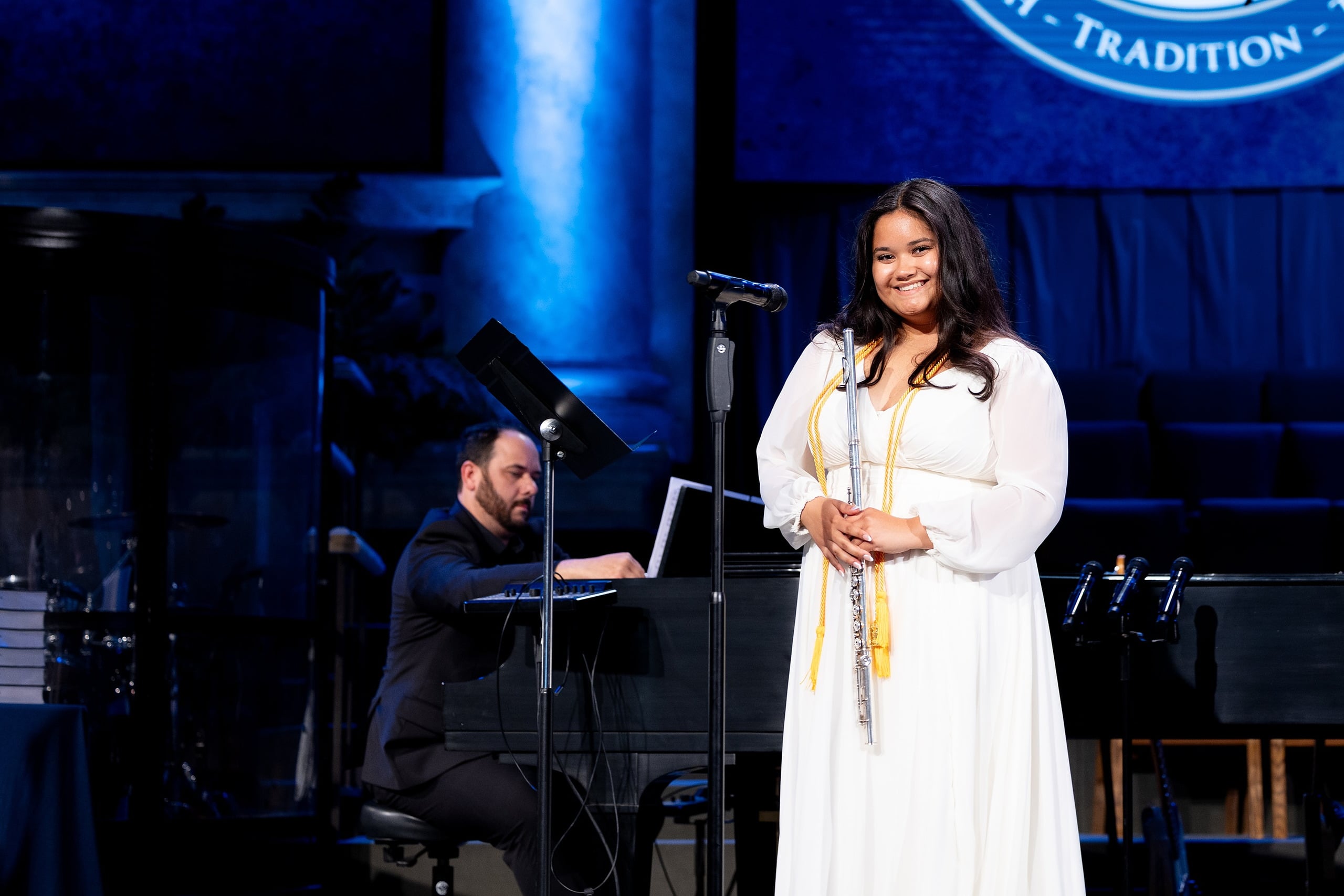Christian High School Commencement 2025: Rise Up — 15 Two female graduates sing together at the microphone during the program