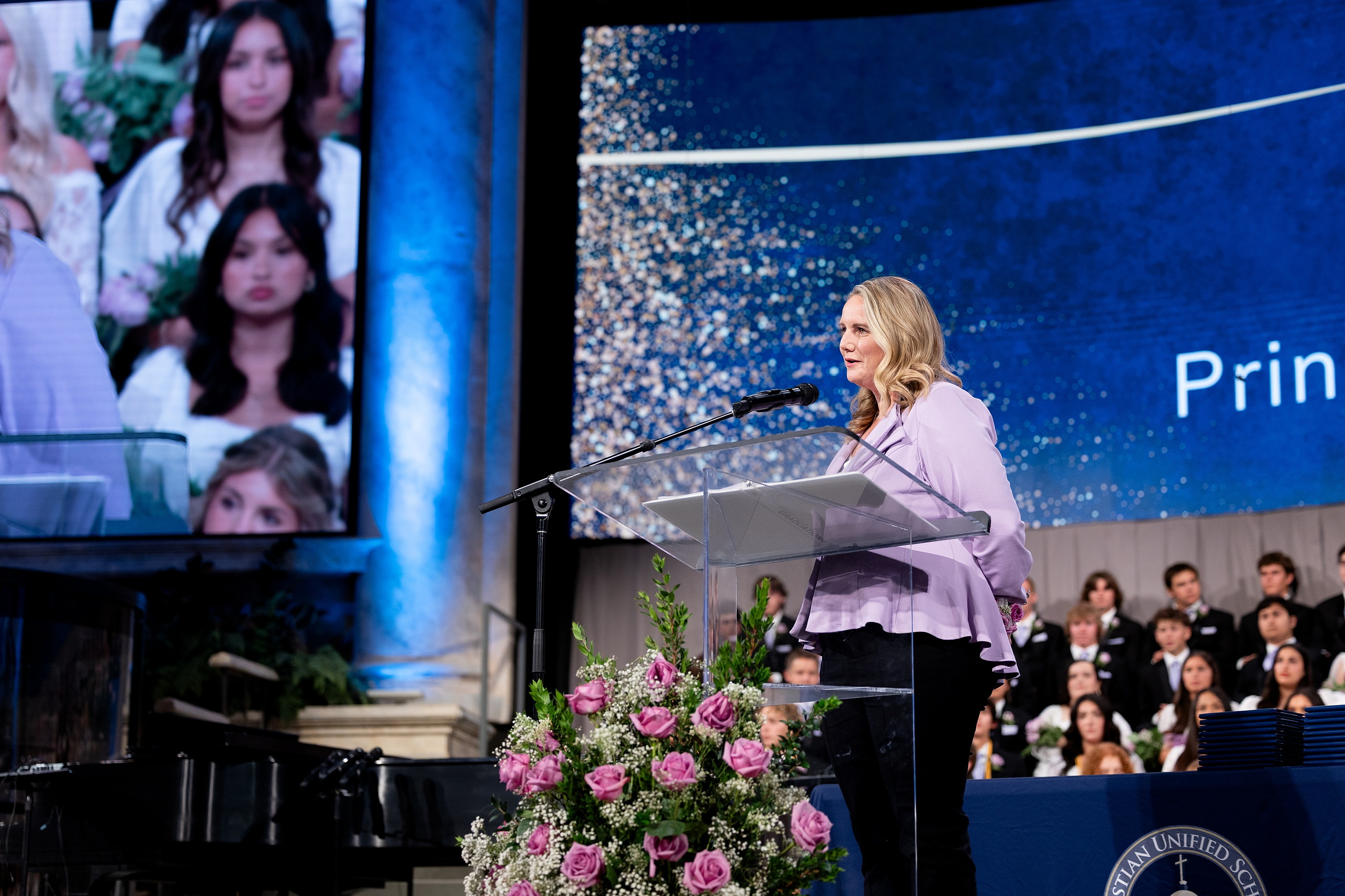 Christian High School Commencement 2025: Rise Up — 18 Female graduate in white dress speaks at the podium during the ceremony