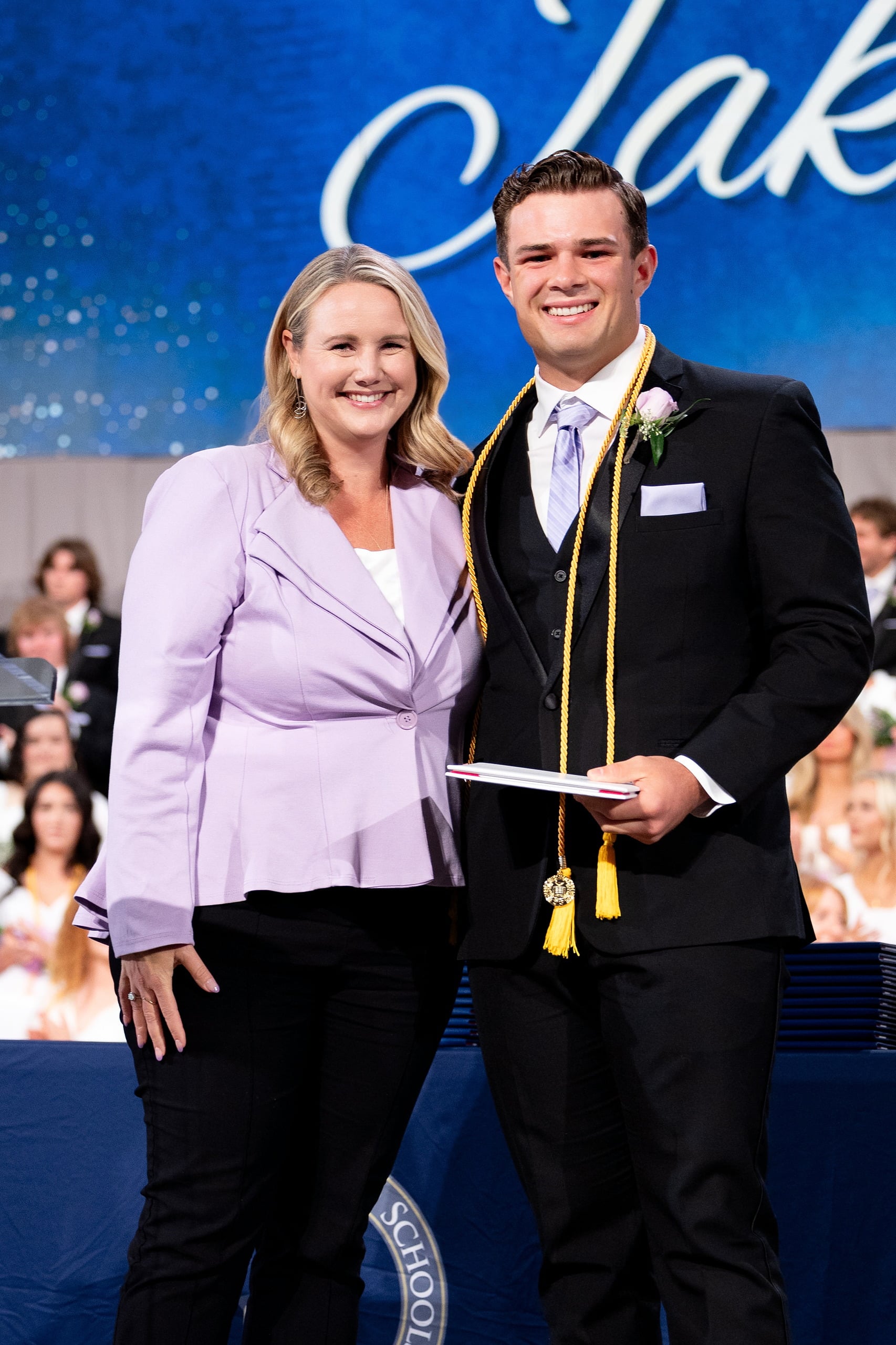 Christian High School Commencement 2025: Rise Up — 26 Female graduate in white dress receives an award from a faculty member