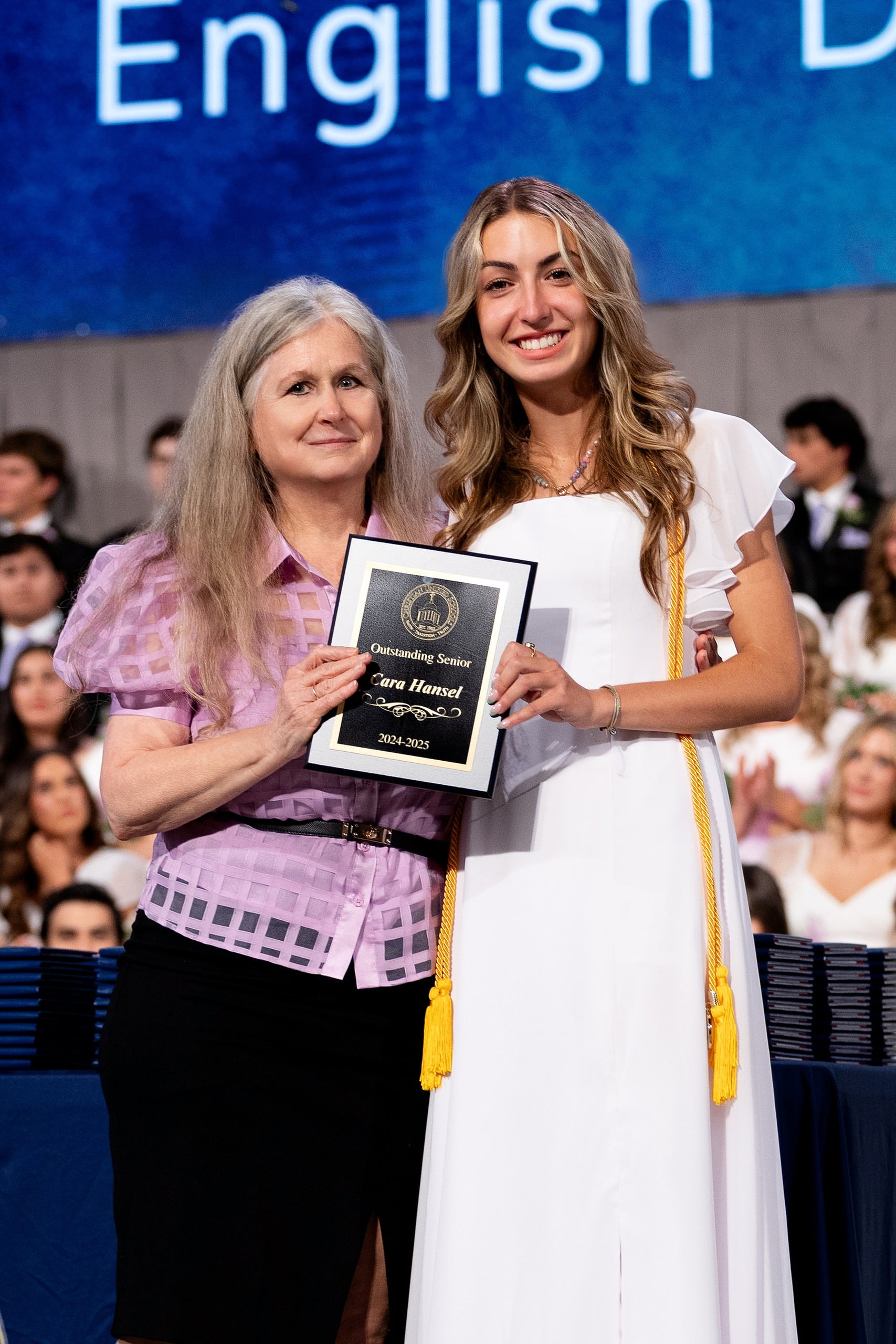 Christian High School Commencement 2025: Rise Up — 28 Graduate receives an award plaque while posing with faculty member on stage