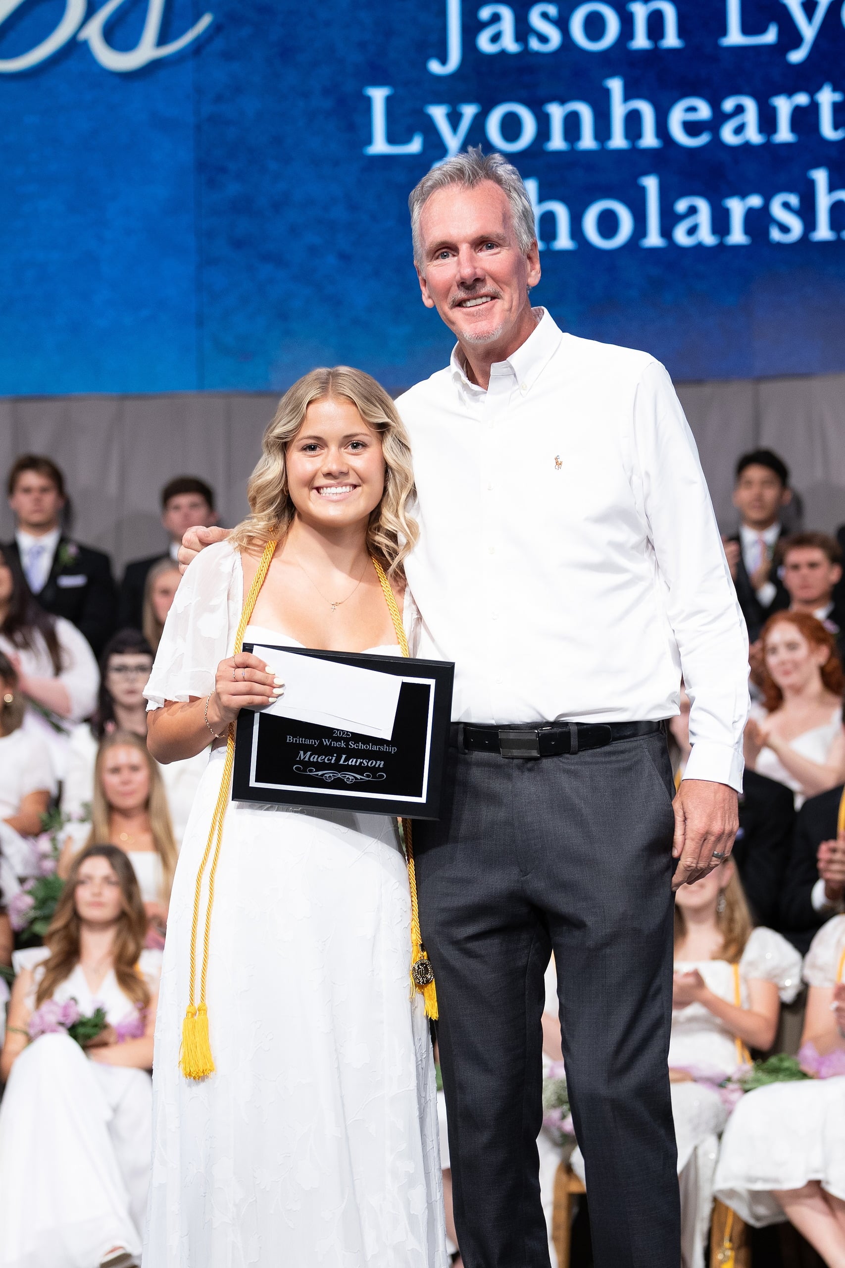 Christian High School Commencement 2025: Rise Up — 32 Female graduate in white dress receives scholarship from family member