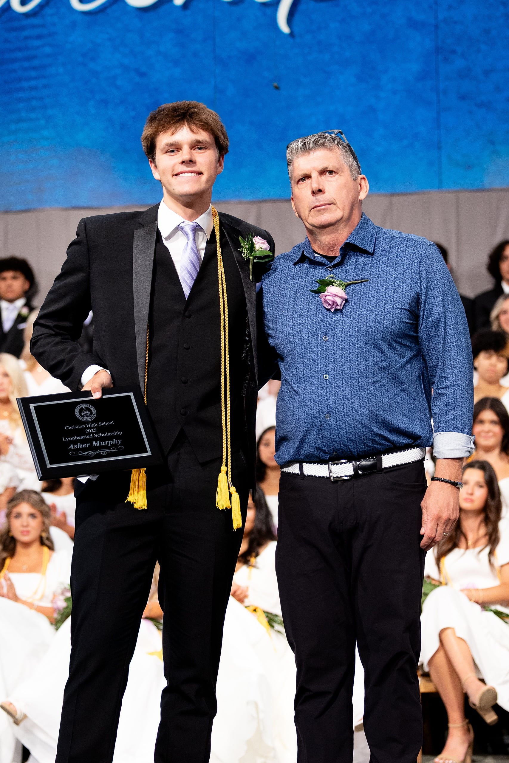 Christian High School Commencement 2025: Rise Up — 33 Male graduate in formal wear accepts a scholarship award at the ceremony