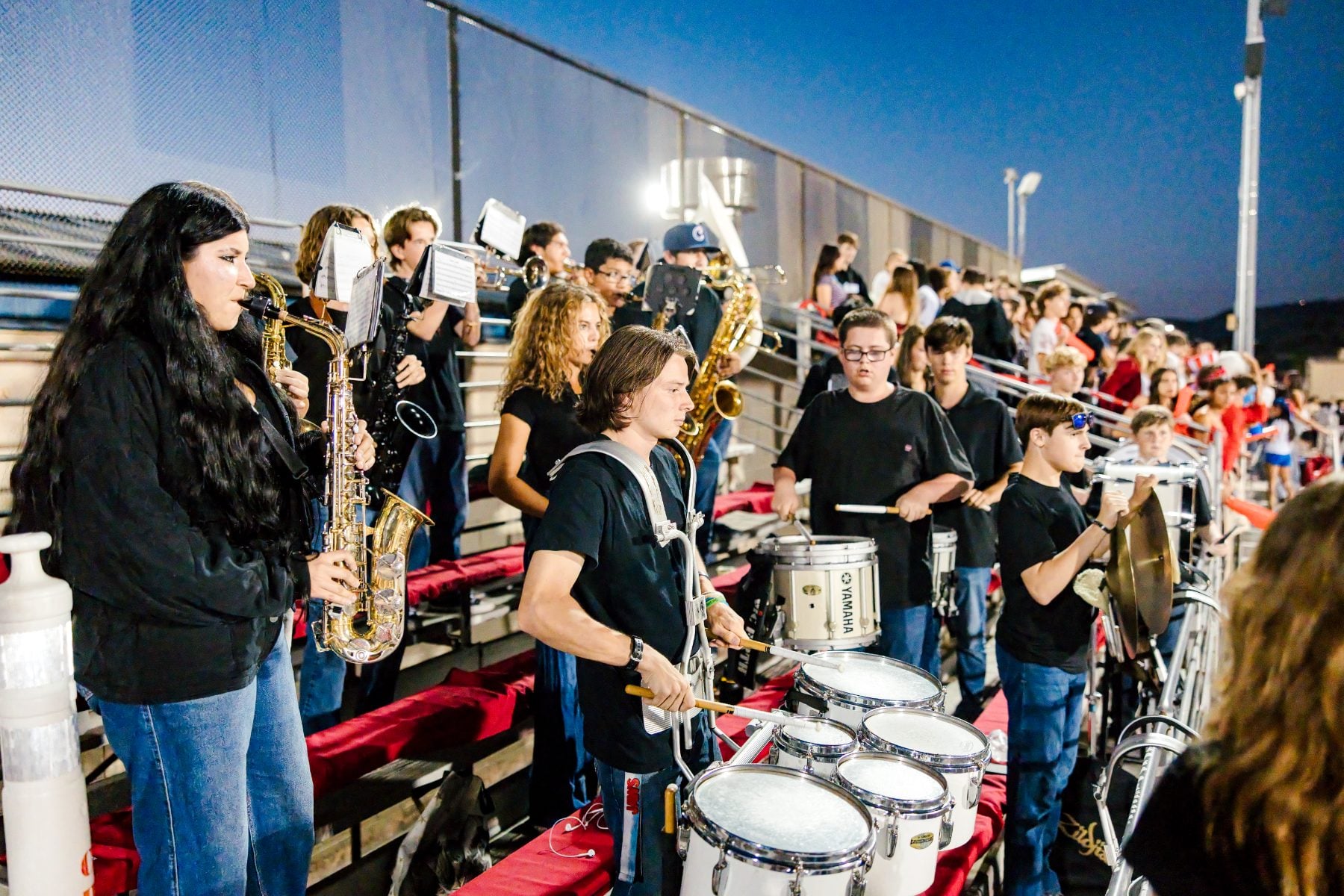 Christian High School pep band members play saxophones and drums in the stands