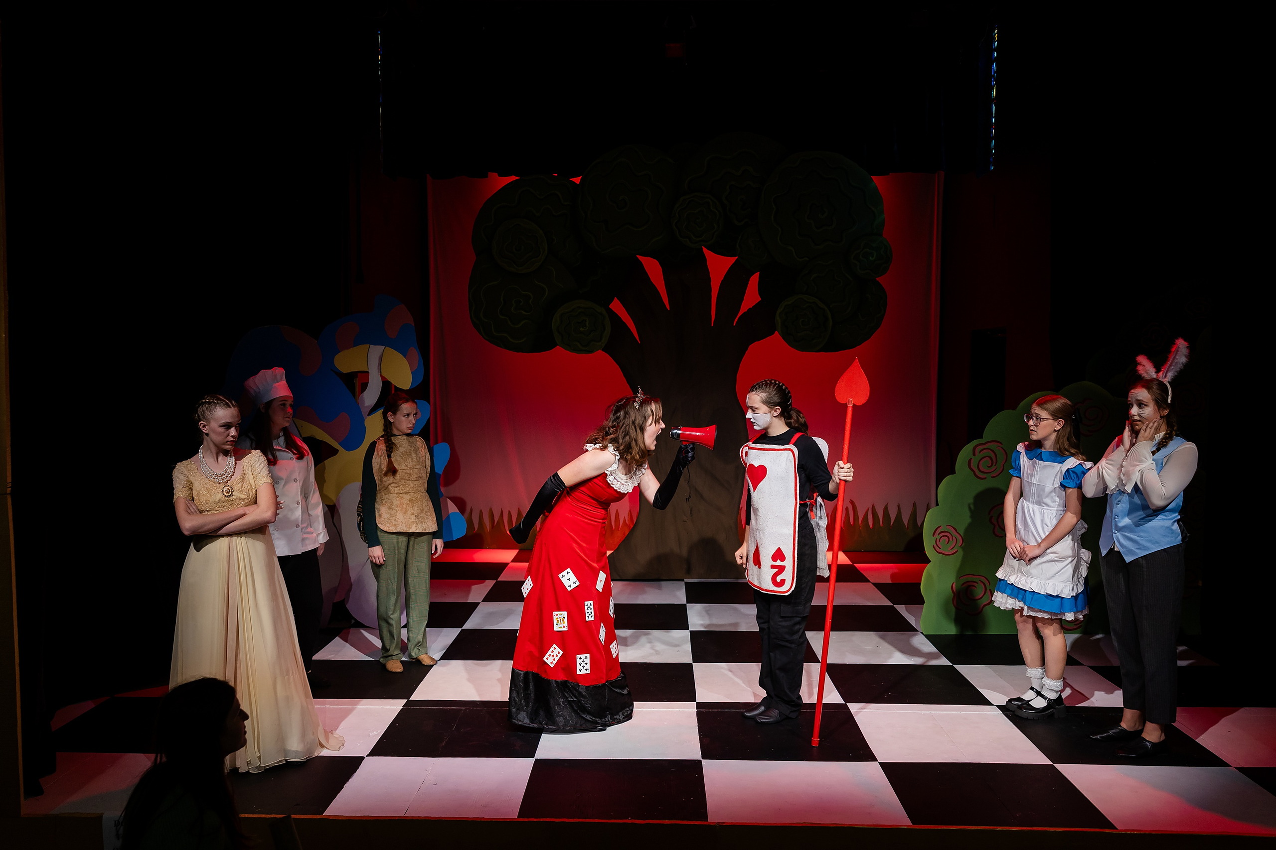 Curiouser and Curiouser! A Whimsical Journey with the Patriot Players — 20 Patriot Players ensemble performs scene with Queen of Hearts set pieces