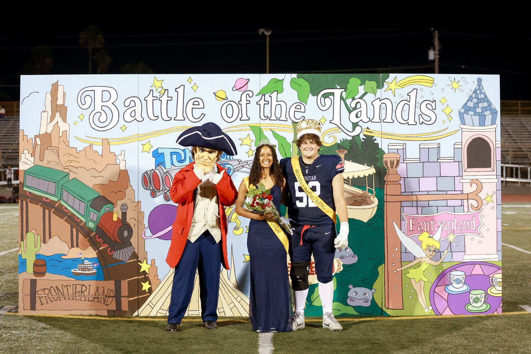 Homecoming king, queen, mascot, and football player pose at Battle of the Lands